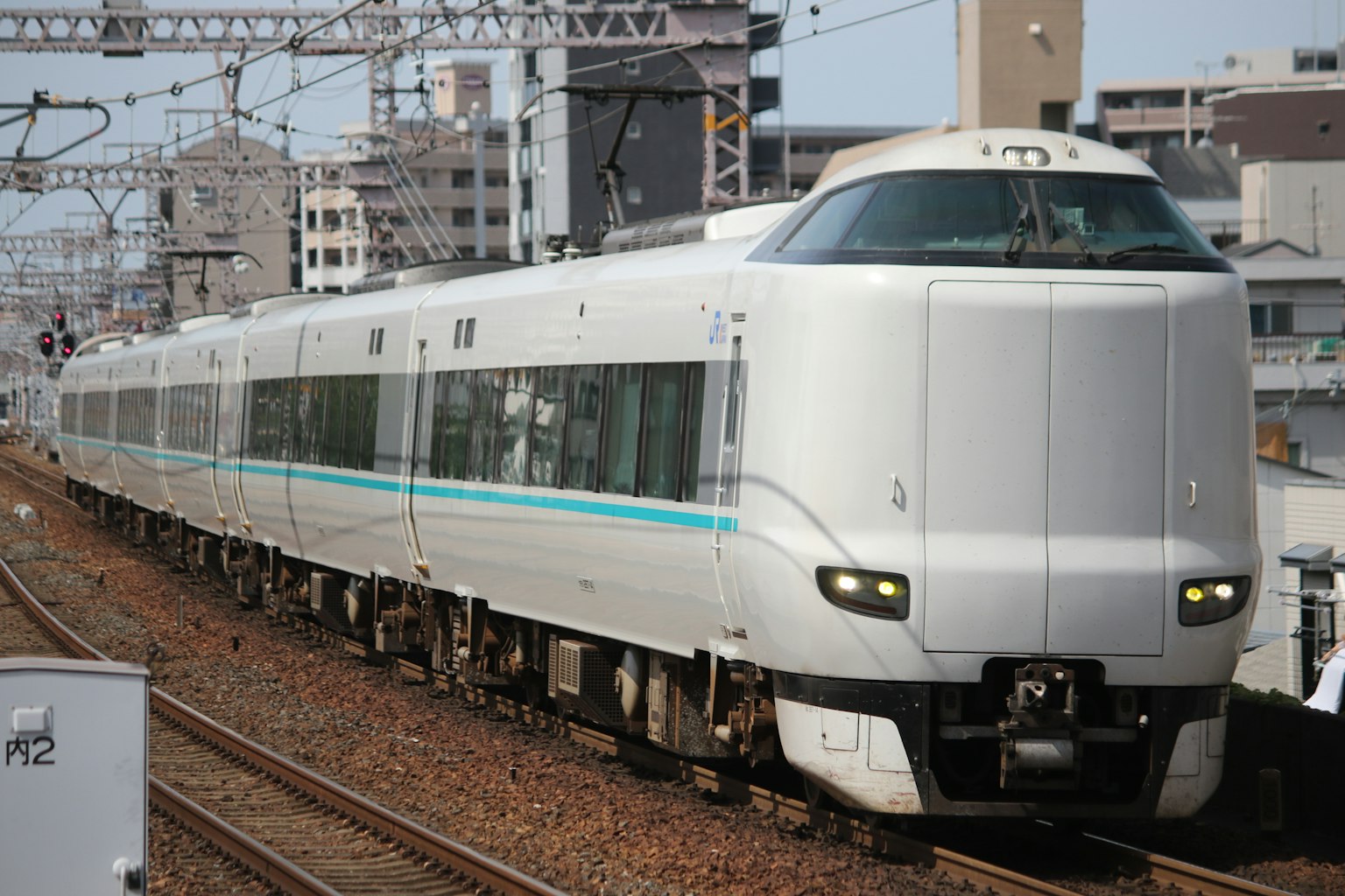 รถไฟชินคันเซนสีขาววิ่งผ่านบรรยากาศในเมือง