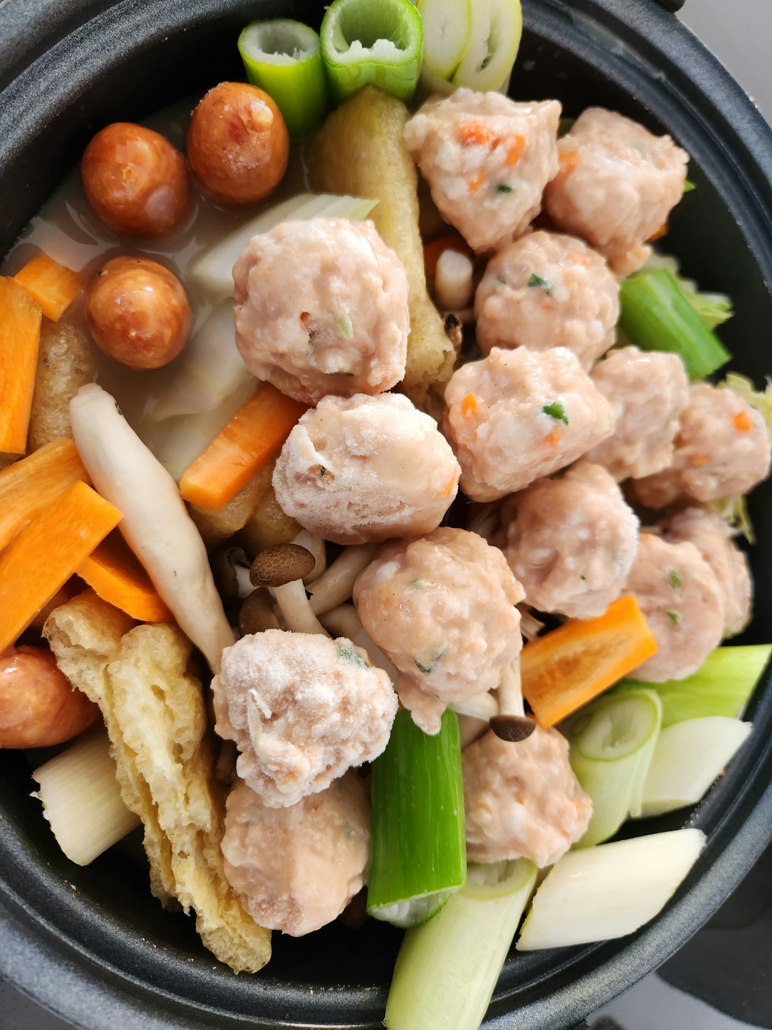Sebuah panci yang penuh dengan bakso dan berbagai sayuran