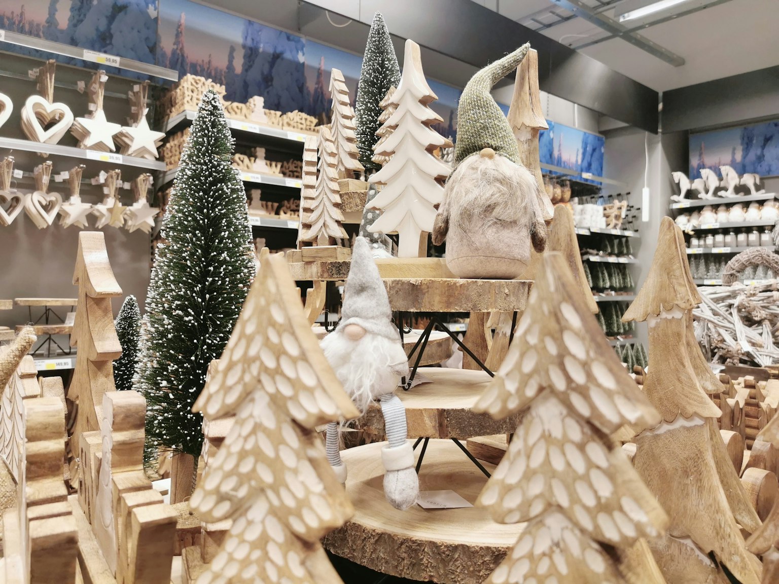 Des arbres de Noël en bois et des décorations exposées dans un magasin