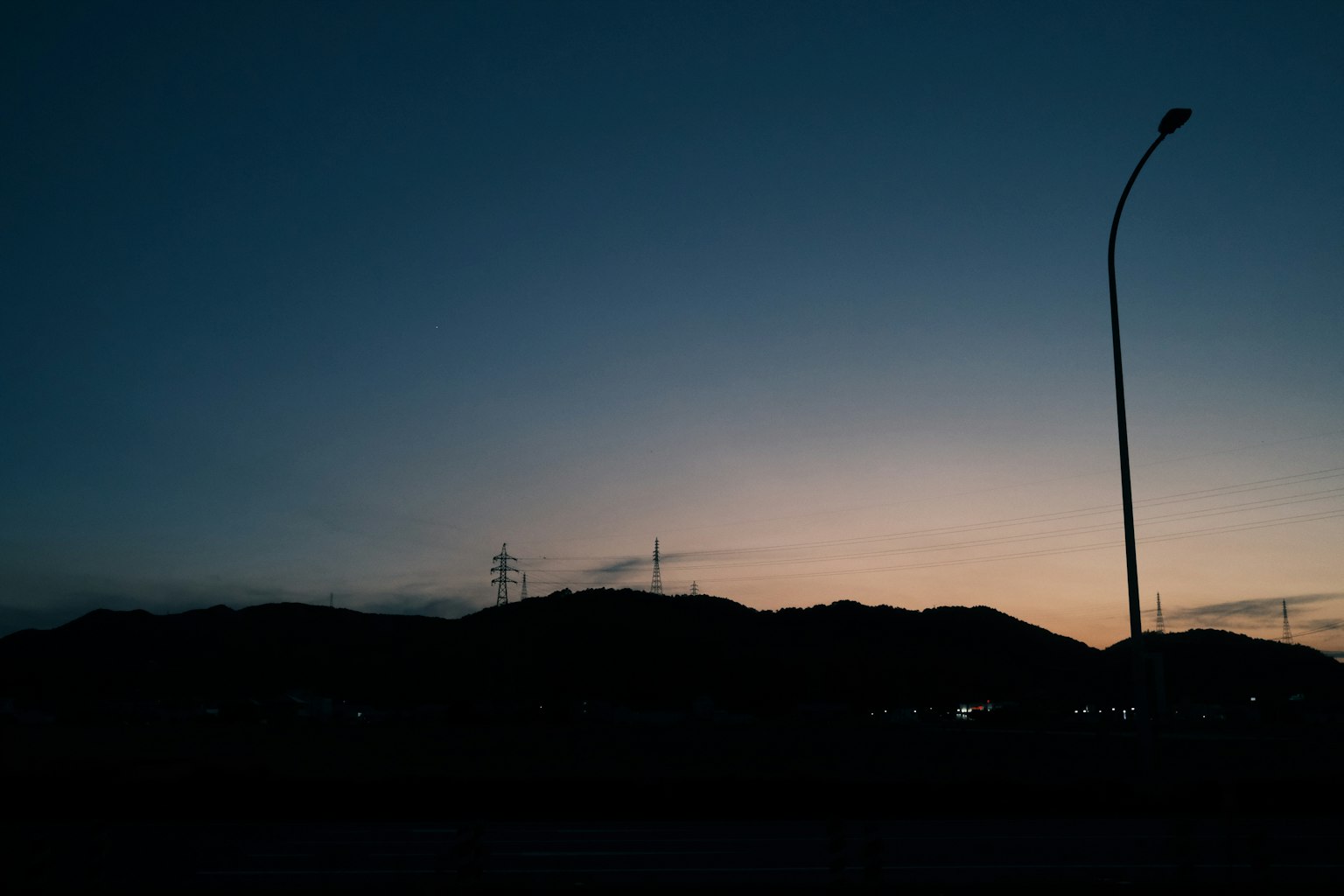 Silhouette de montagnes au crépuscule avec un lampadaire