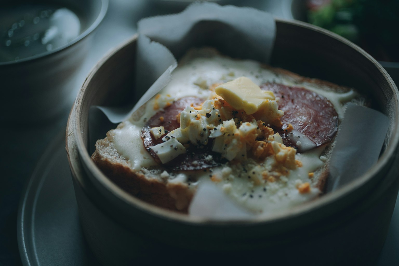 un plat servi dans un bol de pain garni de fromage et de jambon