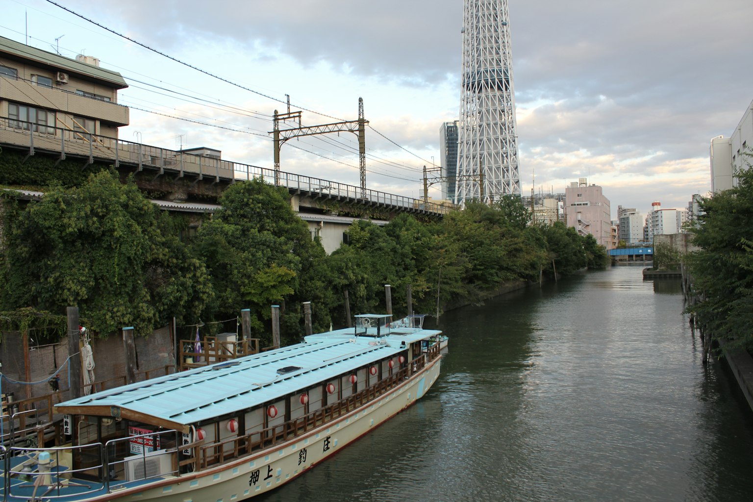 เรือดั้งเดิมในแม่น้ำสุมิดะพร้อมตึกระฟ้าใกล้เคียง