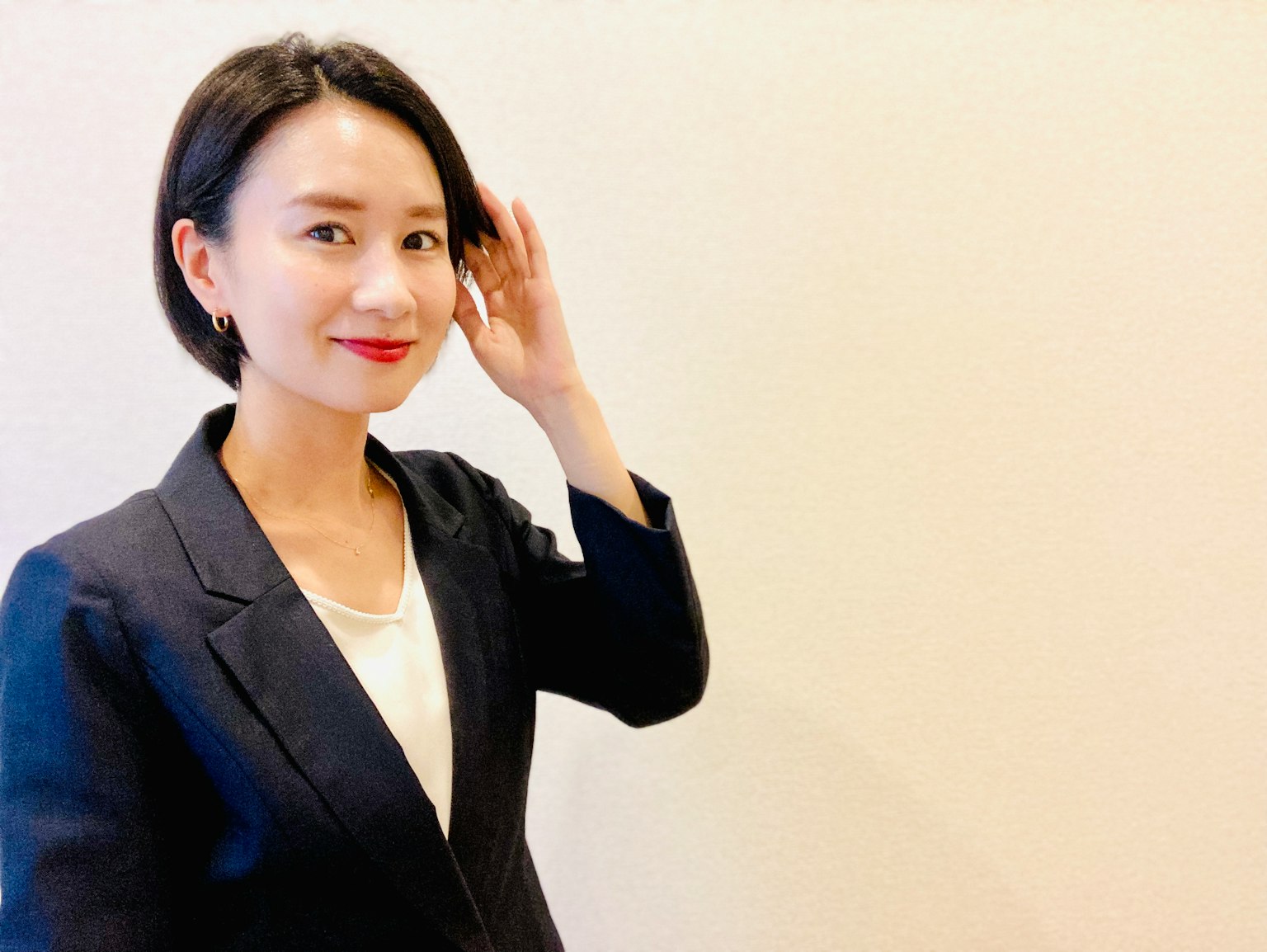一位穿着商务套装的女性微笑着抚摸她的头发