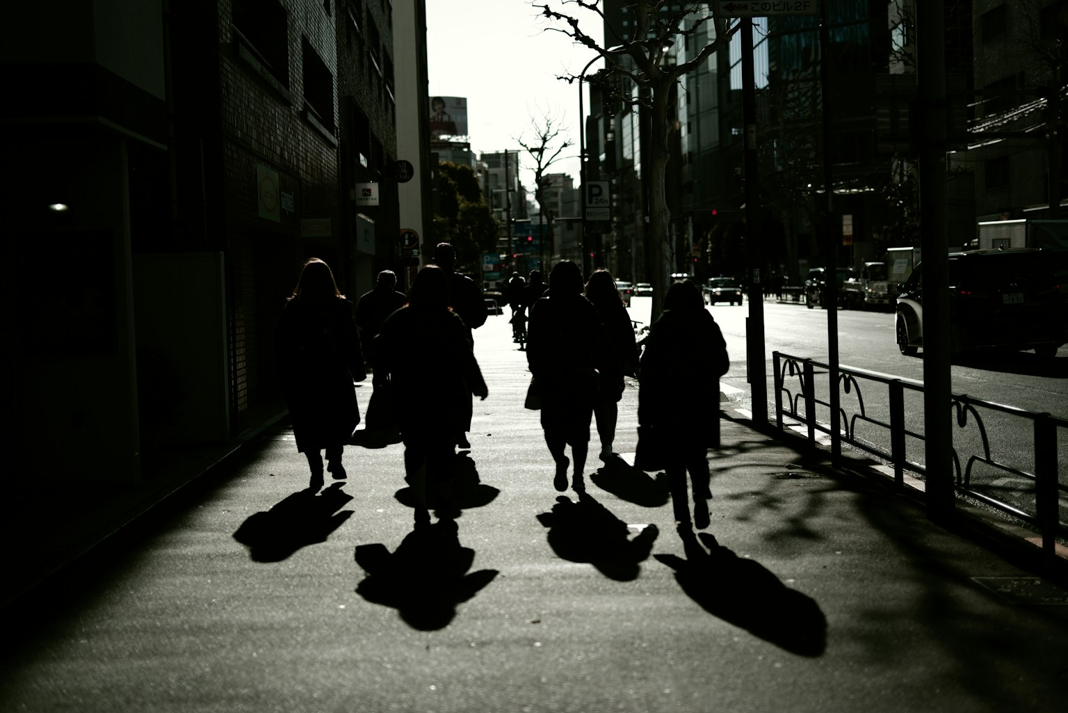 Silhouettes of people walking on a city street