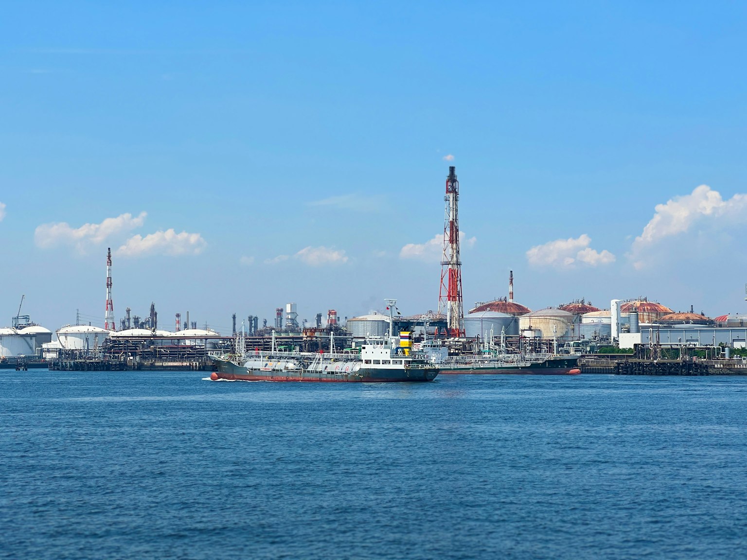 Industriegebiet am Meer mit klarem blauen Himmel und Wasseroberfläche