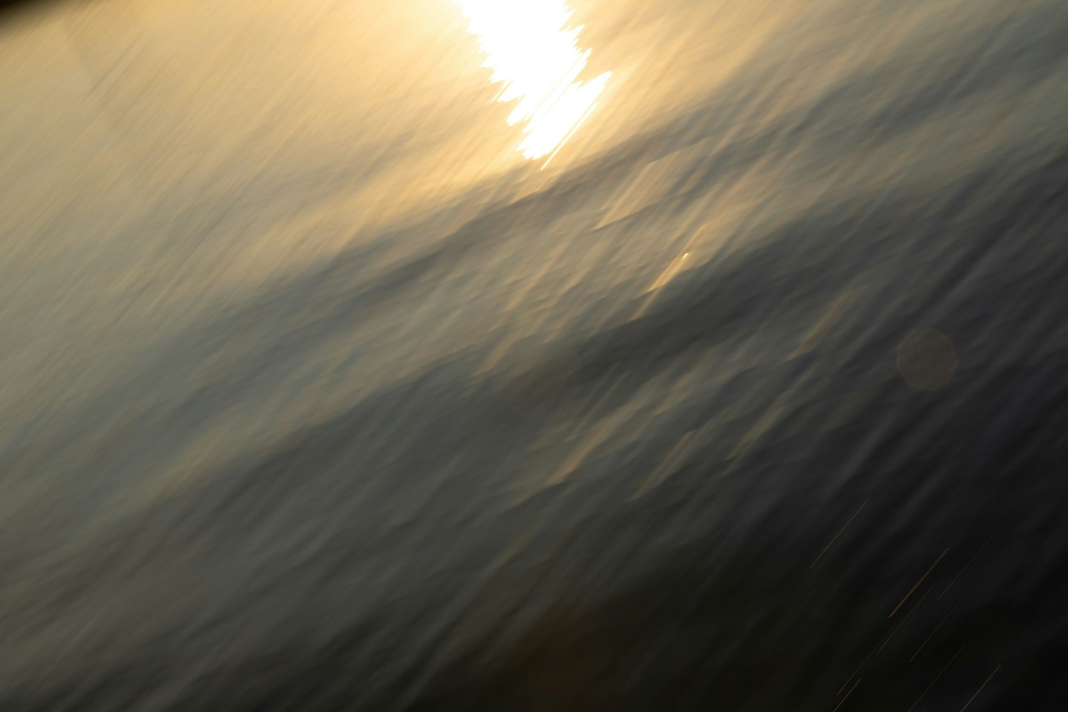 Luce morbida del tramonto che si riflette sulla superficie dell'acqua con onde leggere