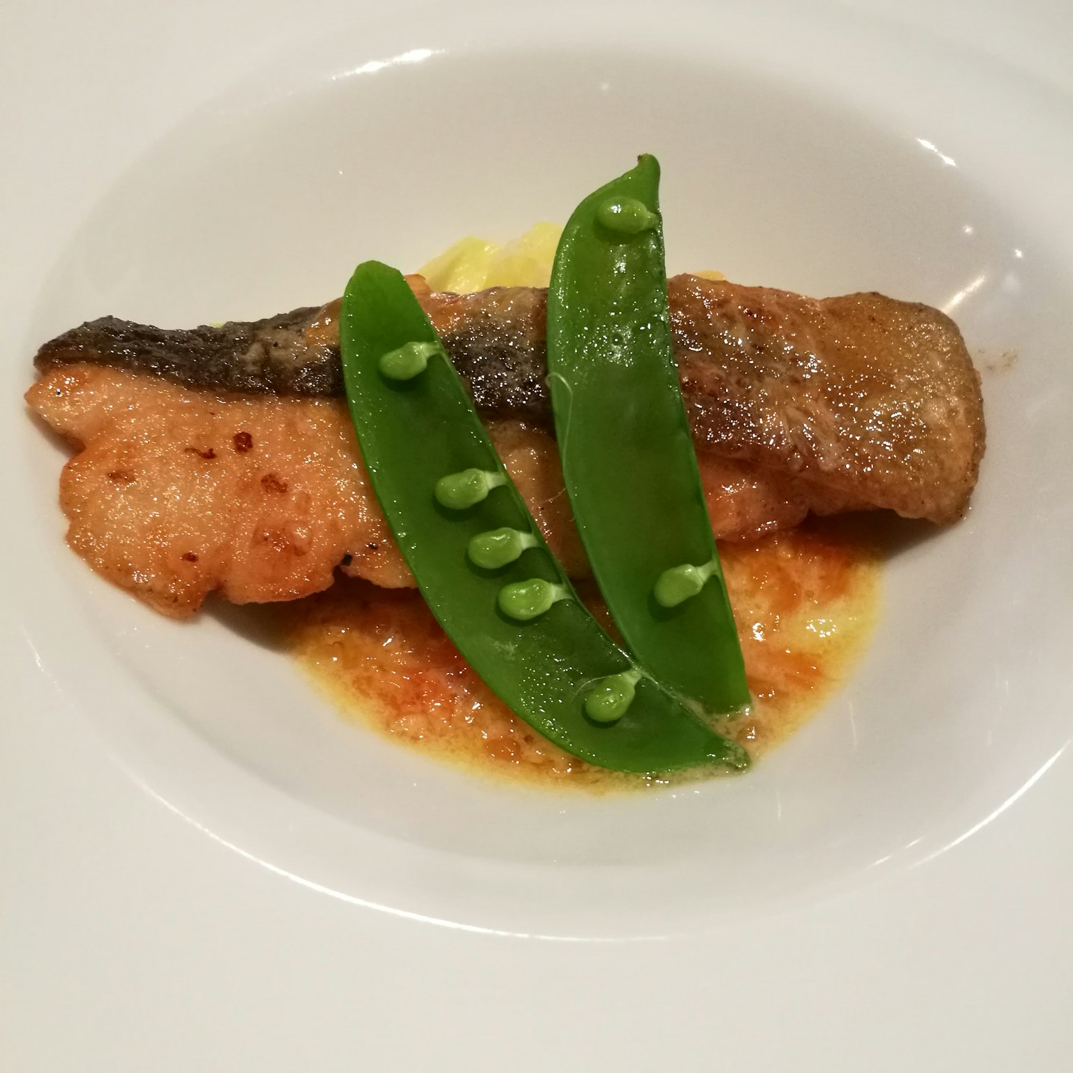 Presentasi ikan panggang dengan kacang polong