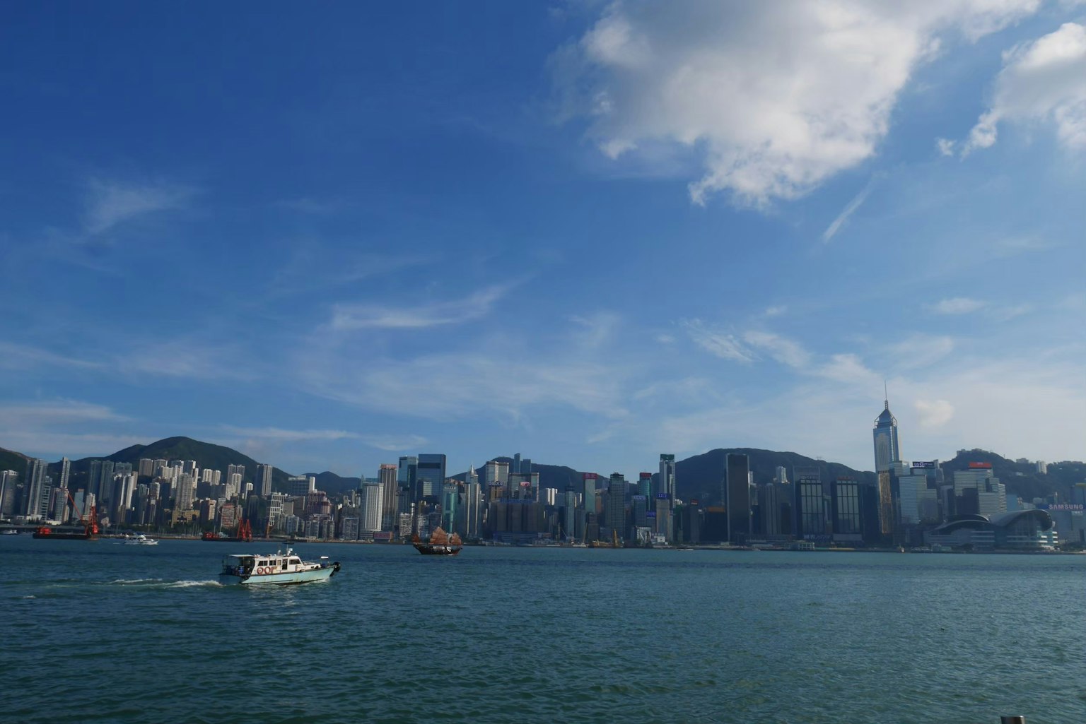 Panoramic view of Hong Kong skyline with skyscrapers and blue sky