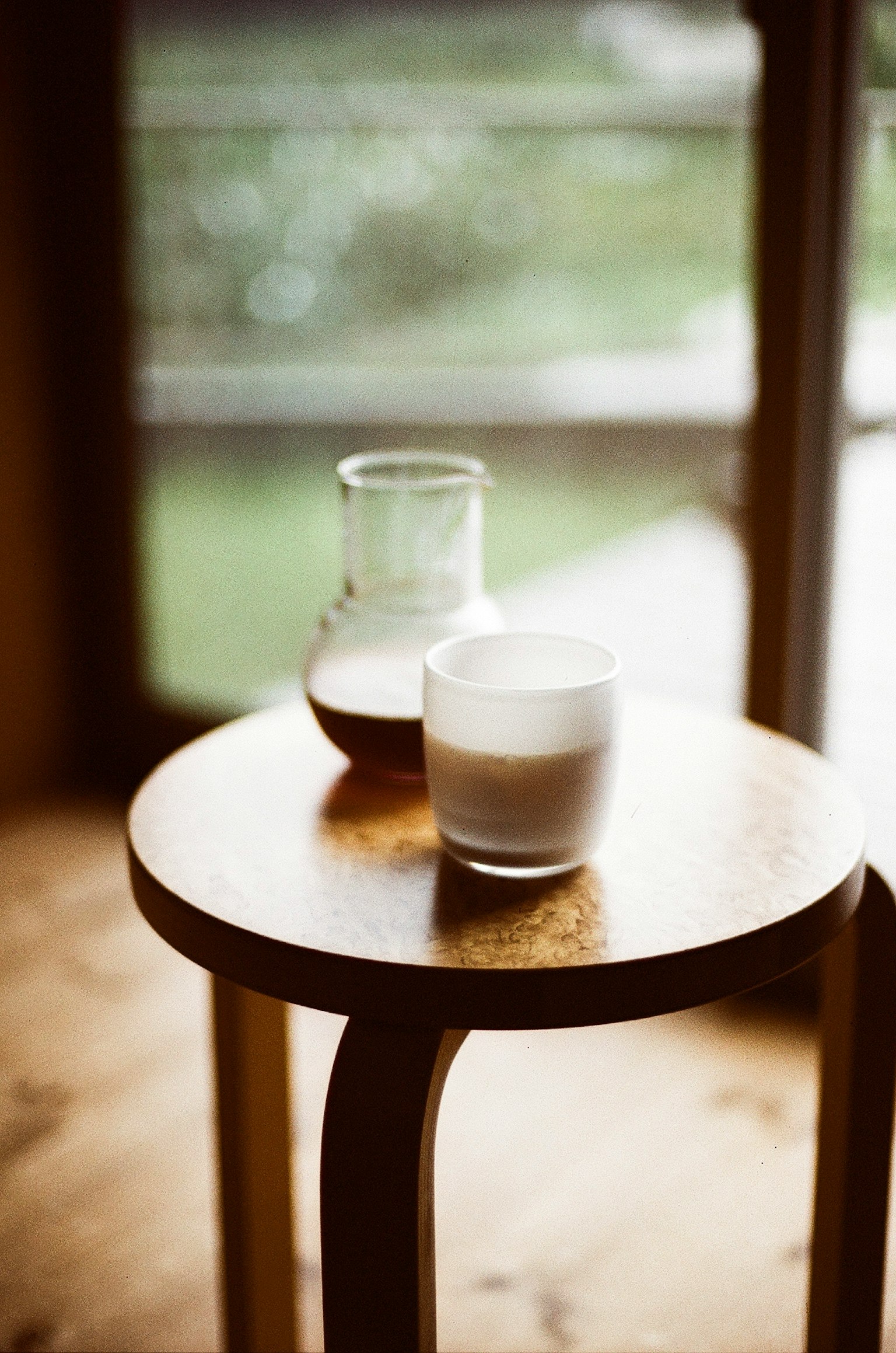 Contenitori di vetro con latte e caffè su un tavolo di legno