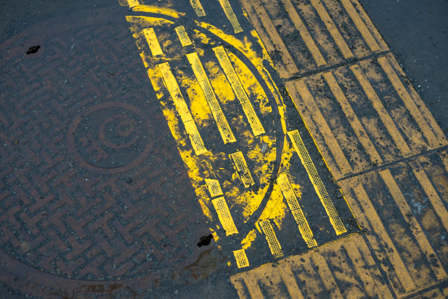 Gros plan sur des marquages jaunes sur le pavé avec des motifs circulaires et linéaires