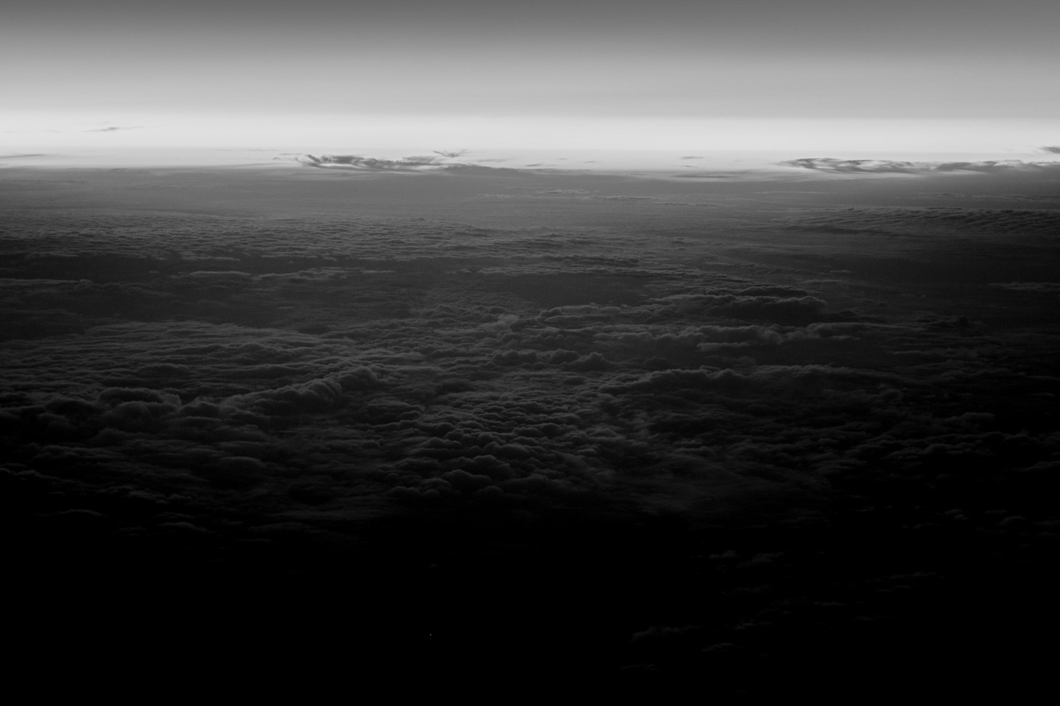 Una vista in bianco e nero di strati di nuvole con un cielo sfumato