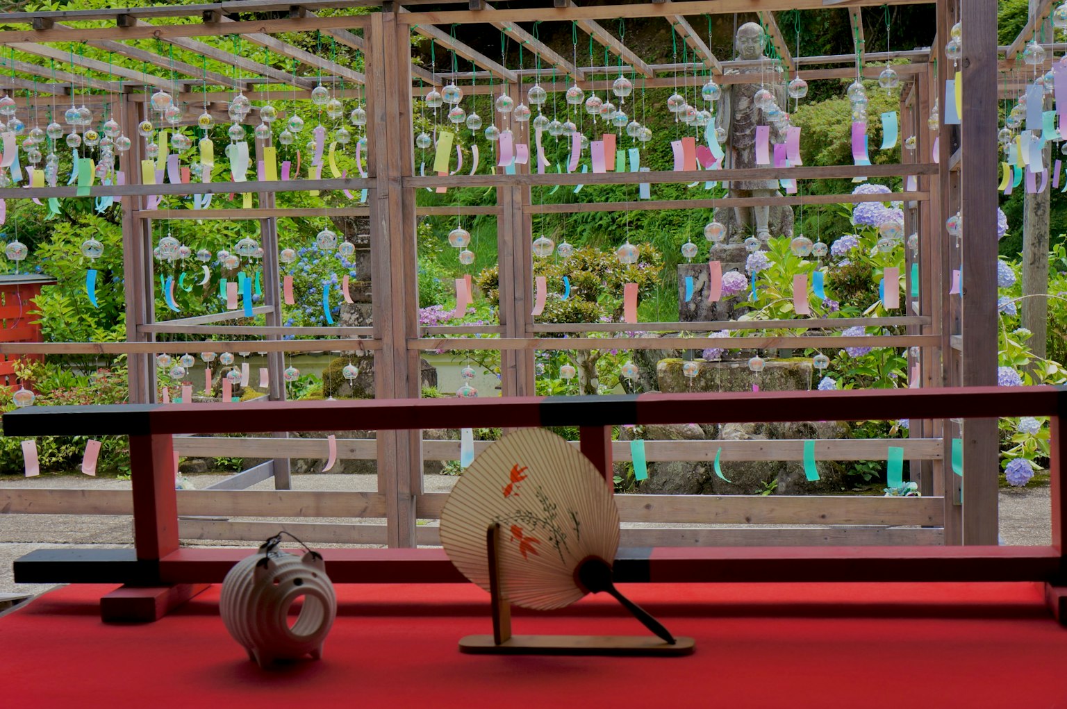 Gelanggang berwarna-warni yang dipajang di taman dengan kipas dan cangkir di latar depan