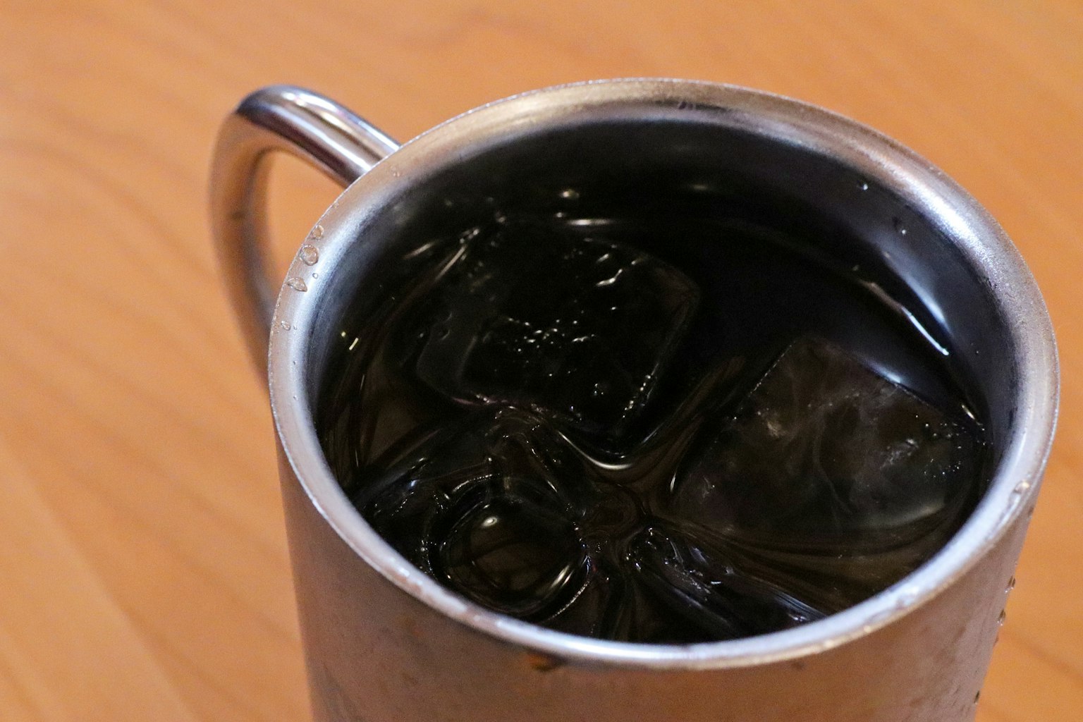 Tasse en métal remplie d'une boisson froide avec des glaçons