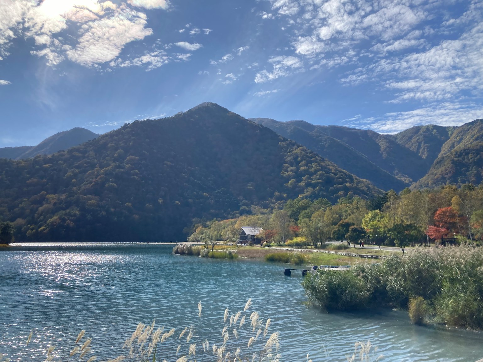 Pemandangan indah pegunungan dan danau langit biru dengan awan pohon dengan dedaunan musim gugur