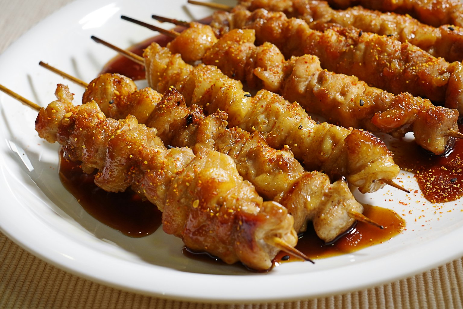 Spiedini di pollo grigliati serviti su un piatto bianco