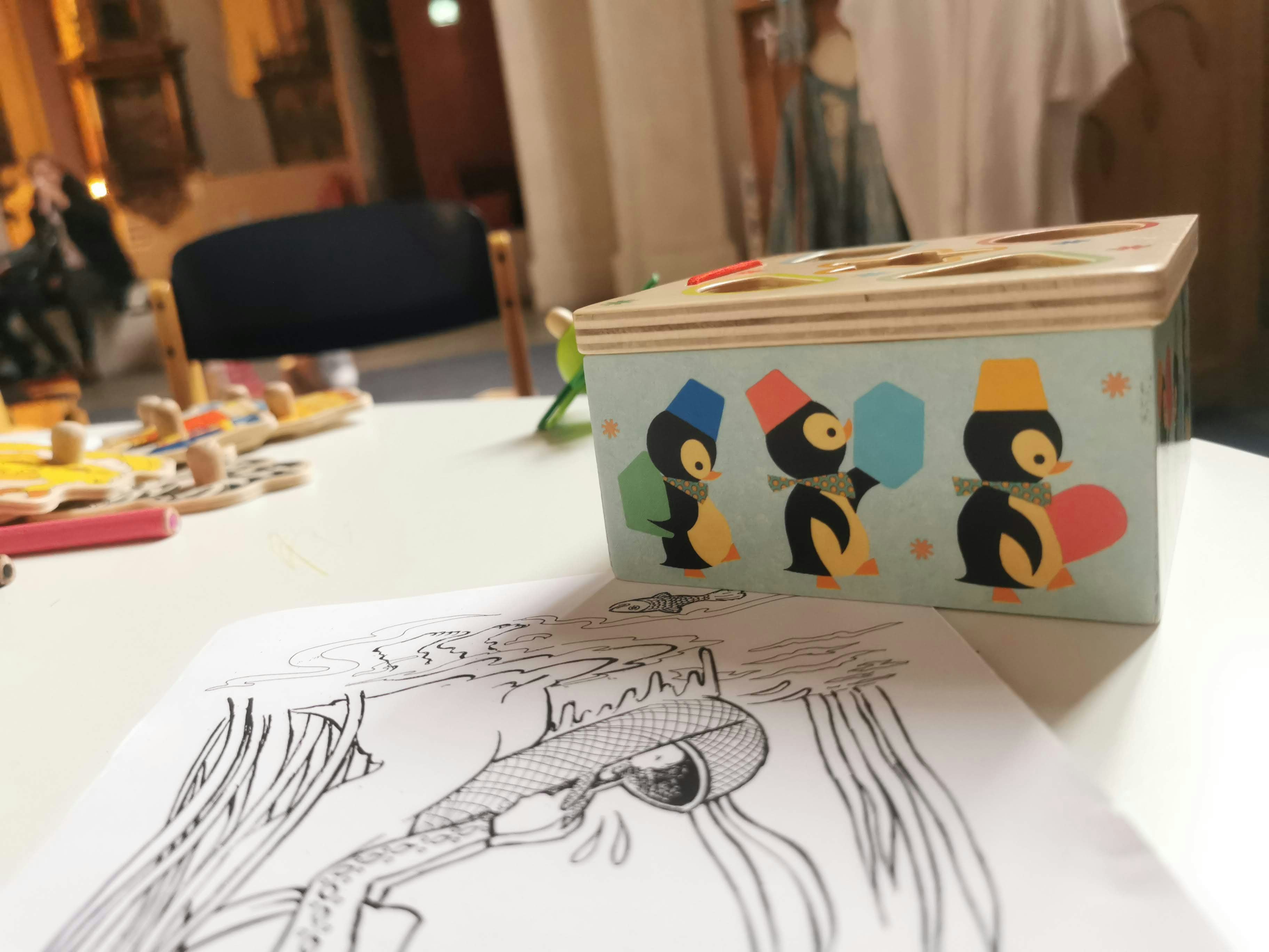 ペン画のイラストと文具が並ぶテーブルの風景