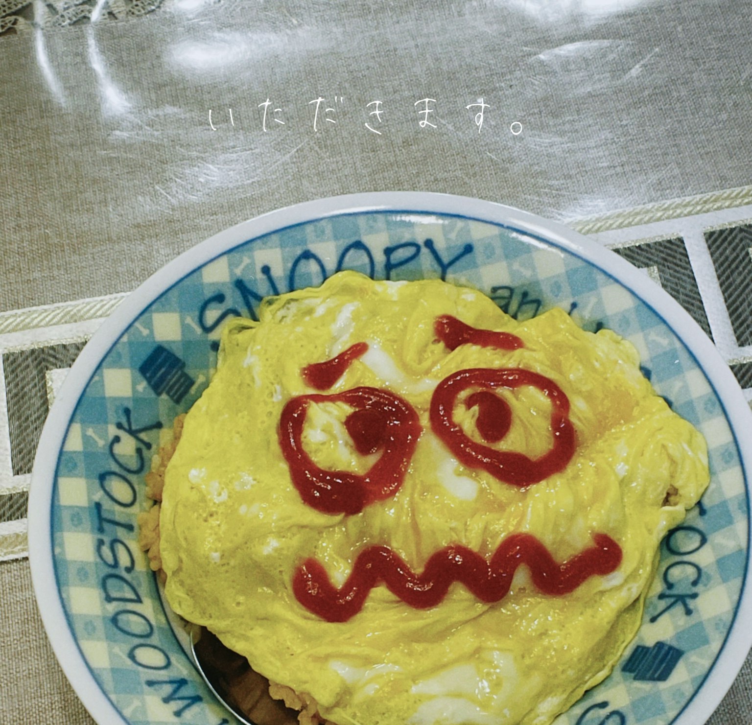 Riso omelette servito su un piatto Snoopy con un volto di ketchup