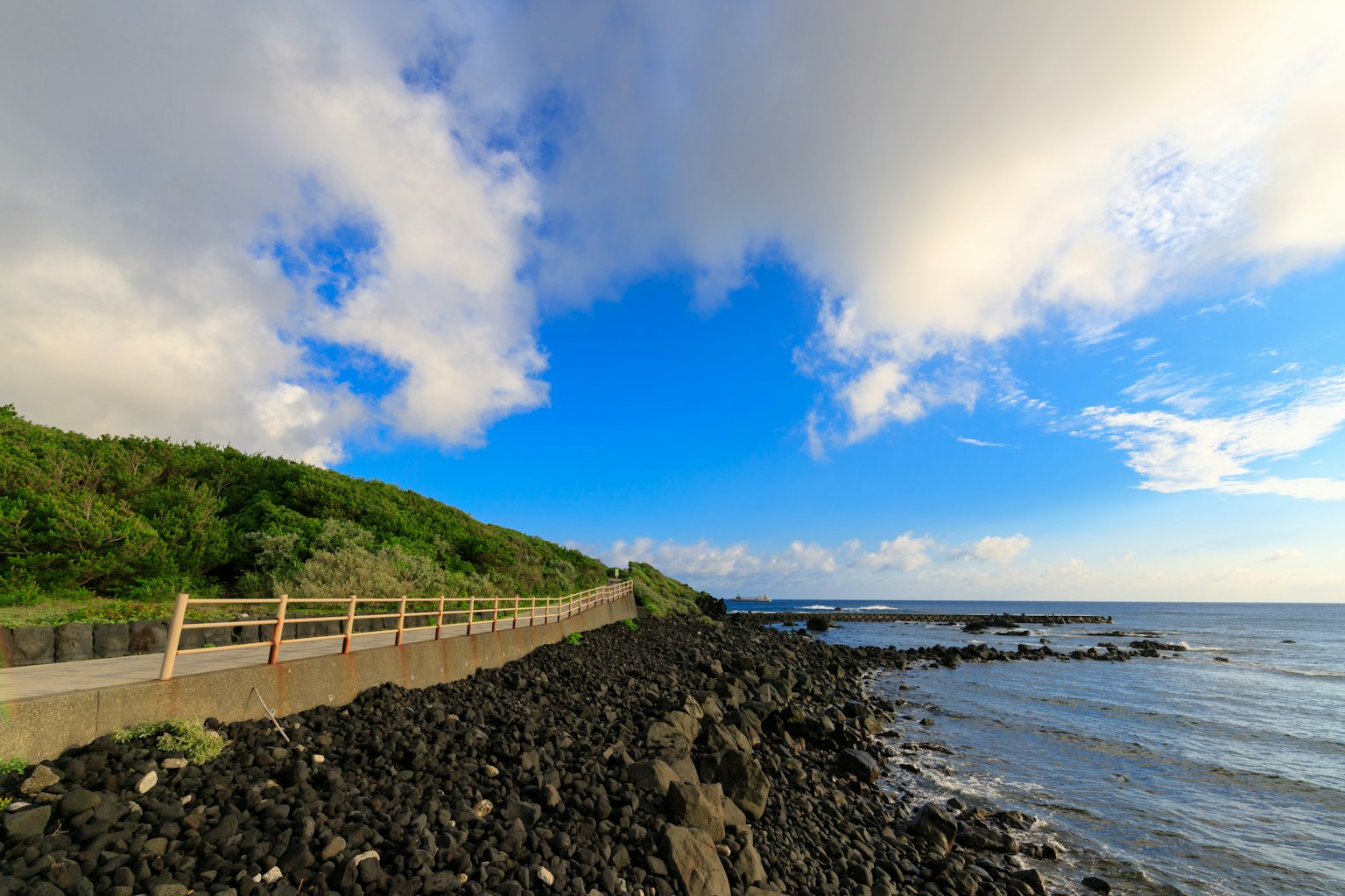 海岸風景 藍天和白雲 岩石海岸和可見的小道