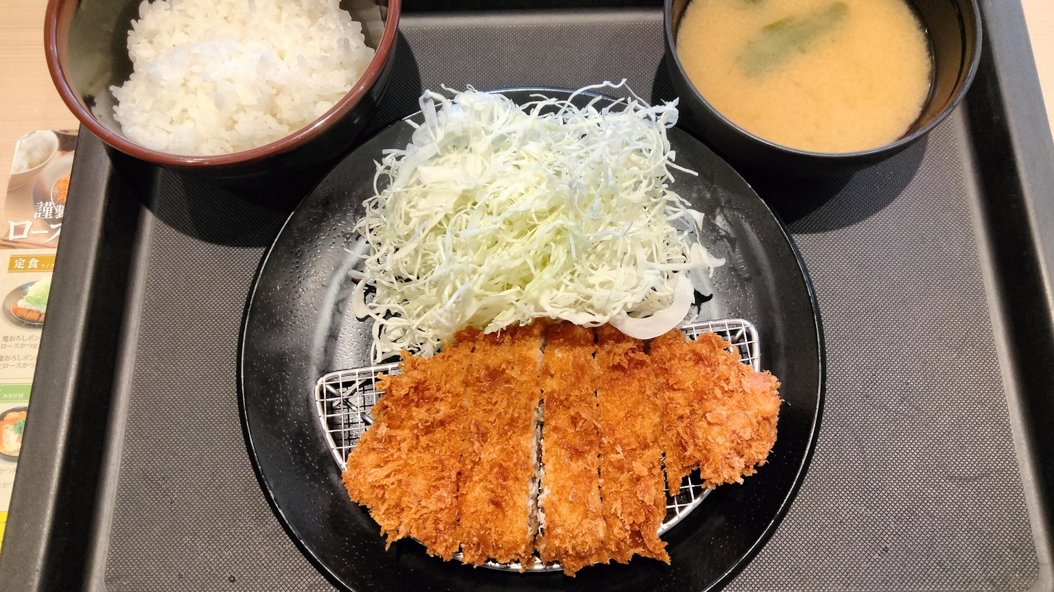 Ein Teller mit Tonkatsu, geraspeltem Kohl, Reis und Miso-Suppe