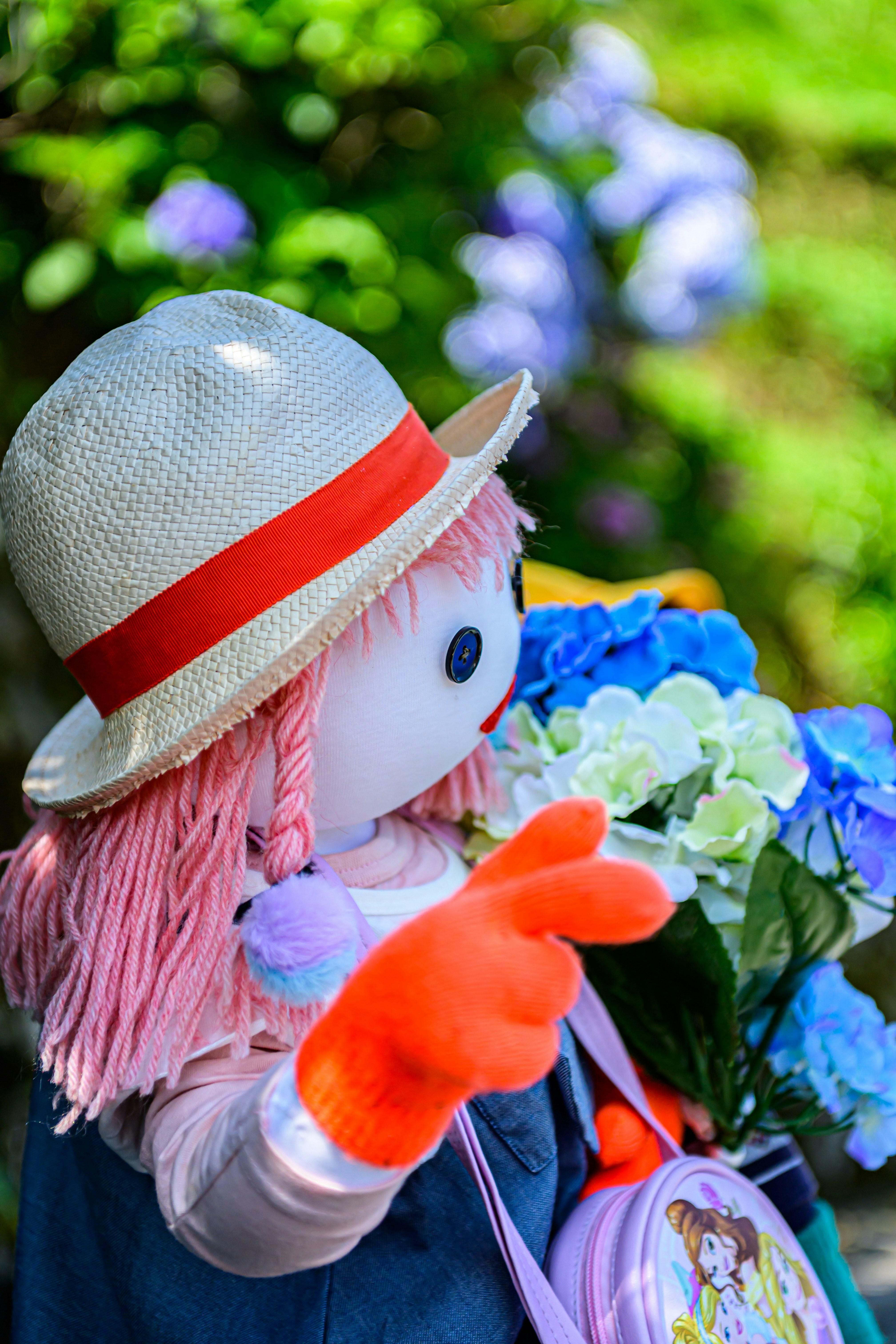jeune fille au chapeau tenant un bouquet dans un jardin de début d’été