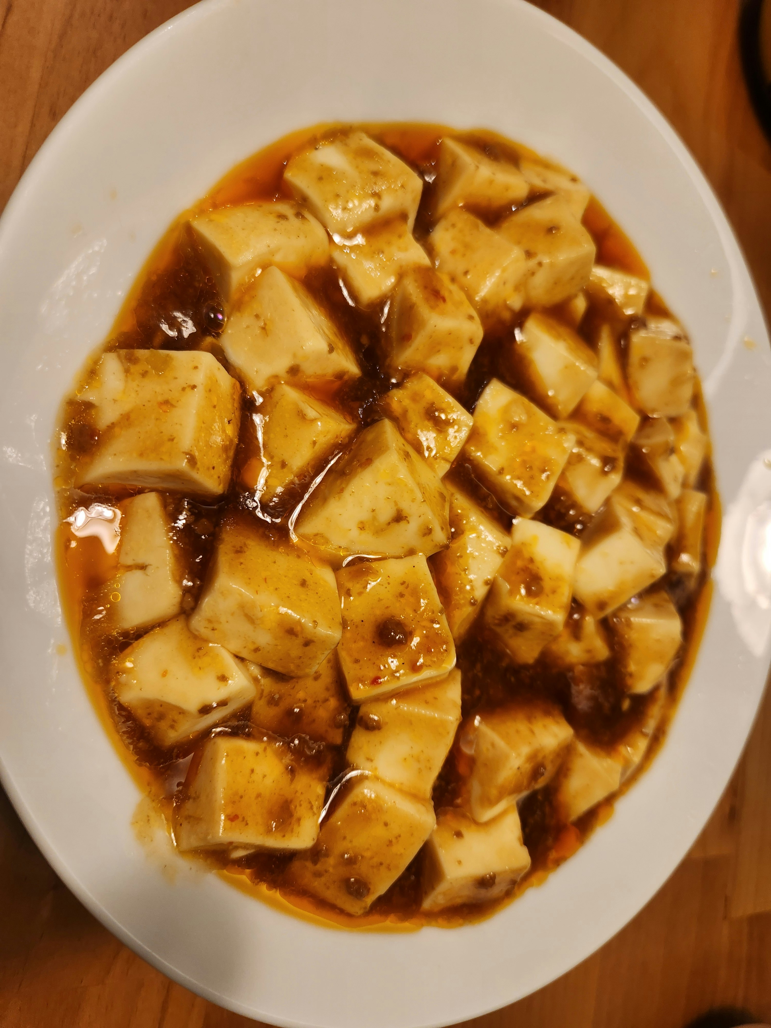 tazón blanco con tofu en cubos en salsa picante