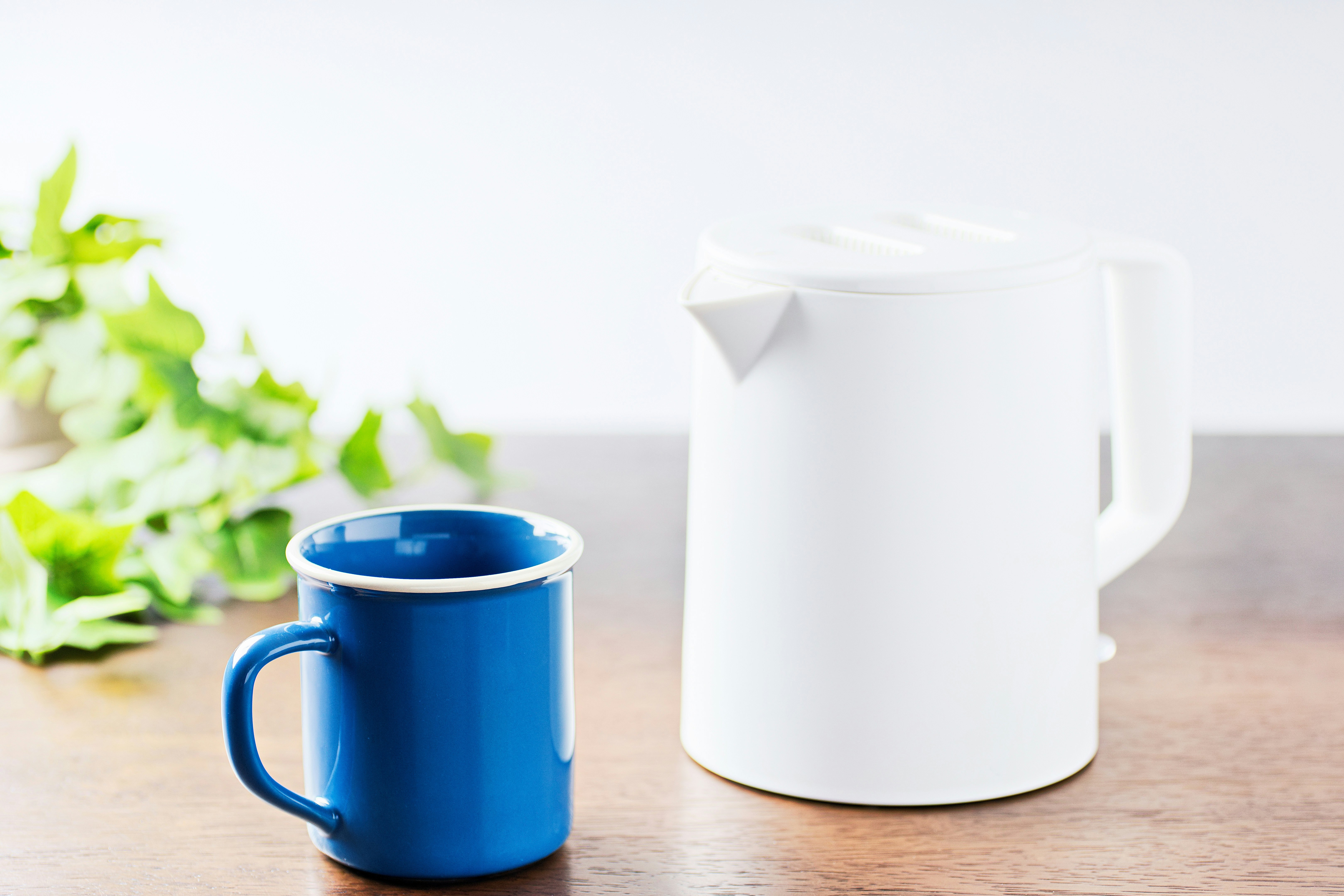 Frühstückstisch mit Tasse und Wasserkocher im Morgenlicht