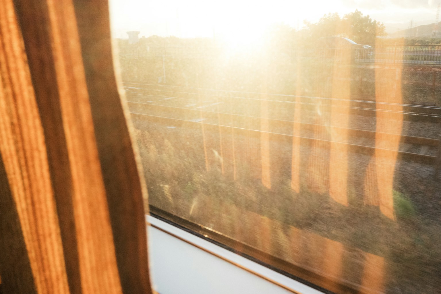 Luce del mattino che filtra da una finestra del treno con motivi della tenda