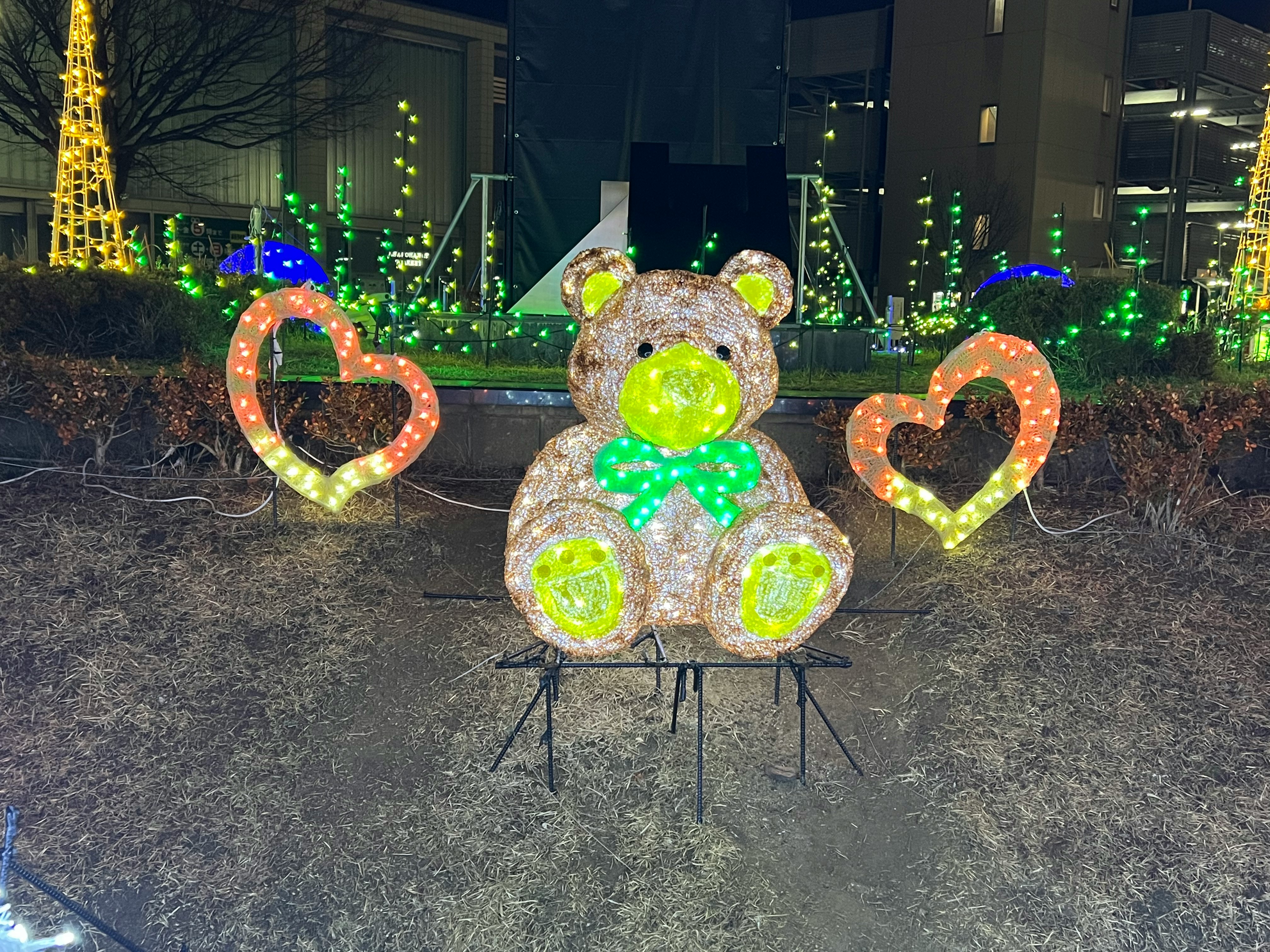 축제 조명 앞에 선 곰 모양 장식