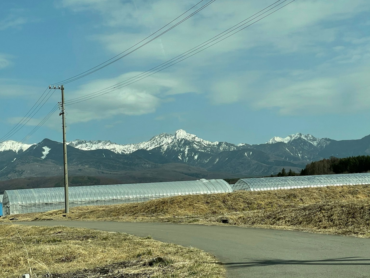 Vista escénica de montañas nevadas y invernaderos transparentes