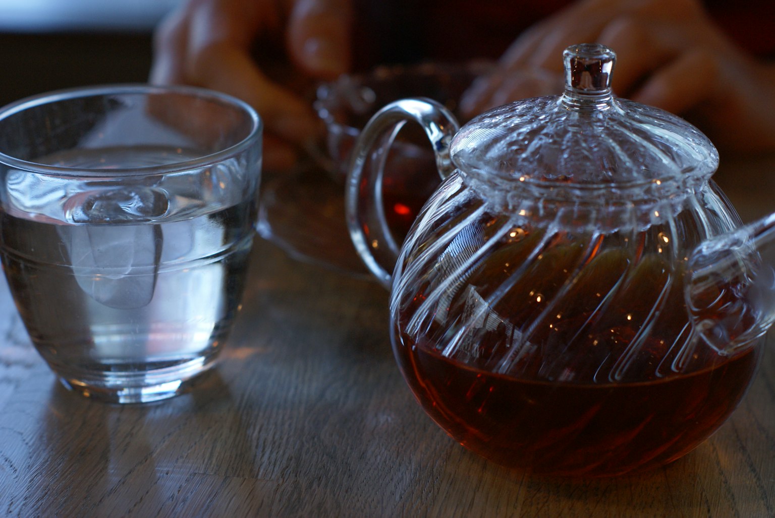Transparente Teekanne und Glas Wasser auf einem Tisch