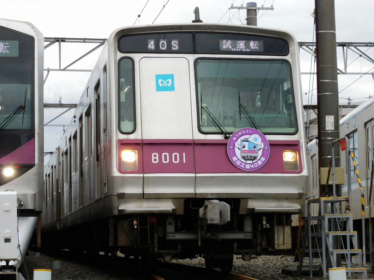 Kereta nomor 8001 berwarna pink dan putih berhenti di stasiun