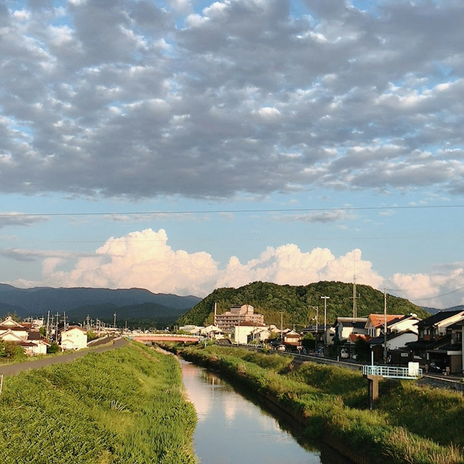 Vue scénique d'une rivière avec des nuages maisons de village et montagnes