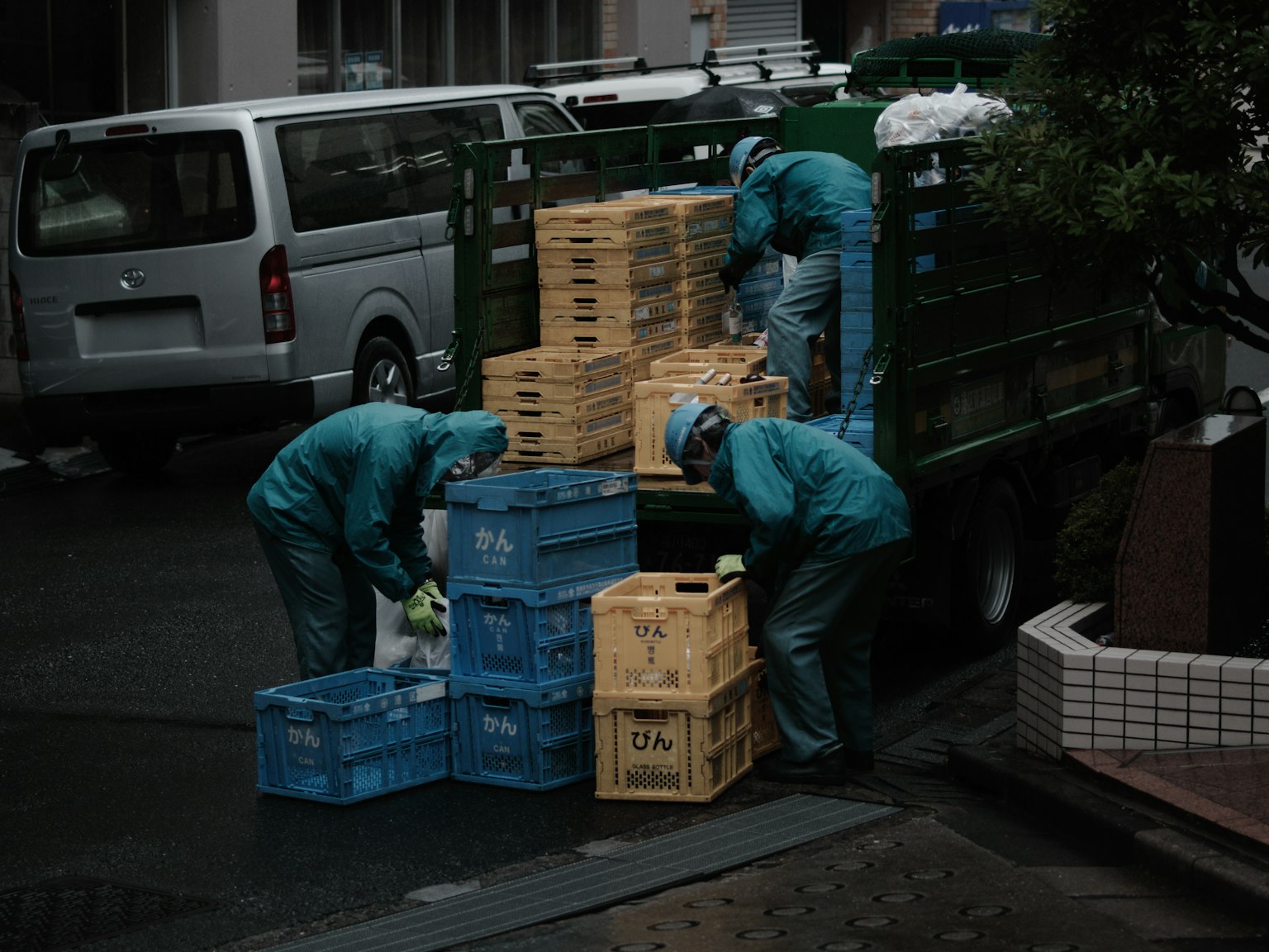 Lavoratori in uniformi blu che scaricano casse da un camion