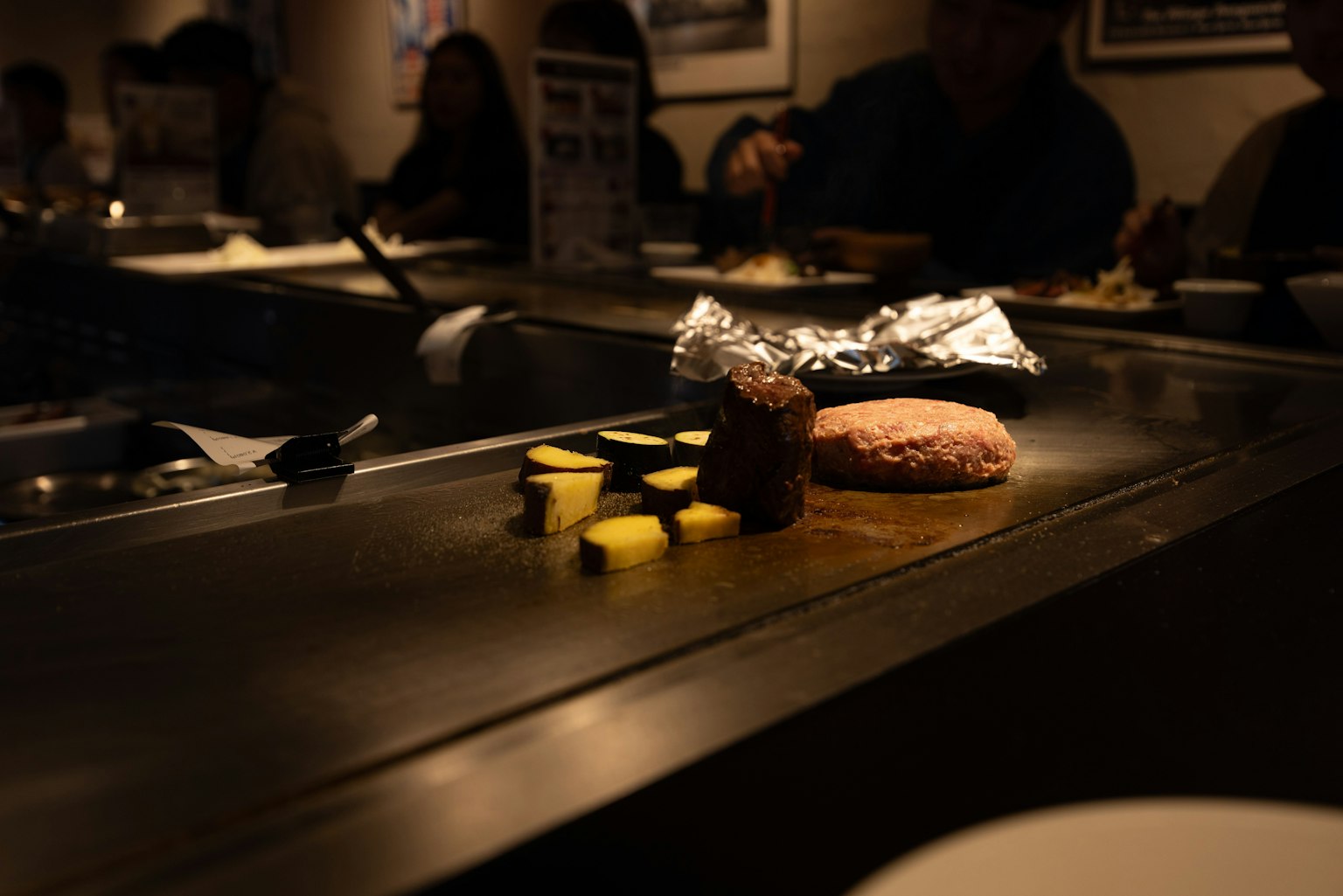 鐵板燒上烤製的蔬菜和漢堡肉餅