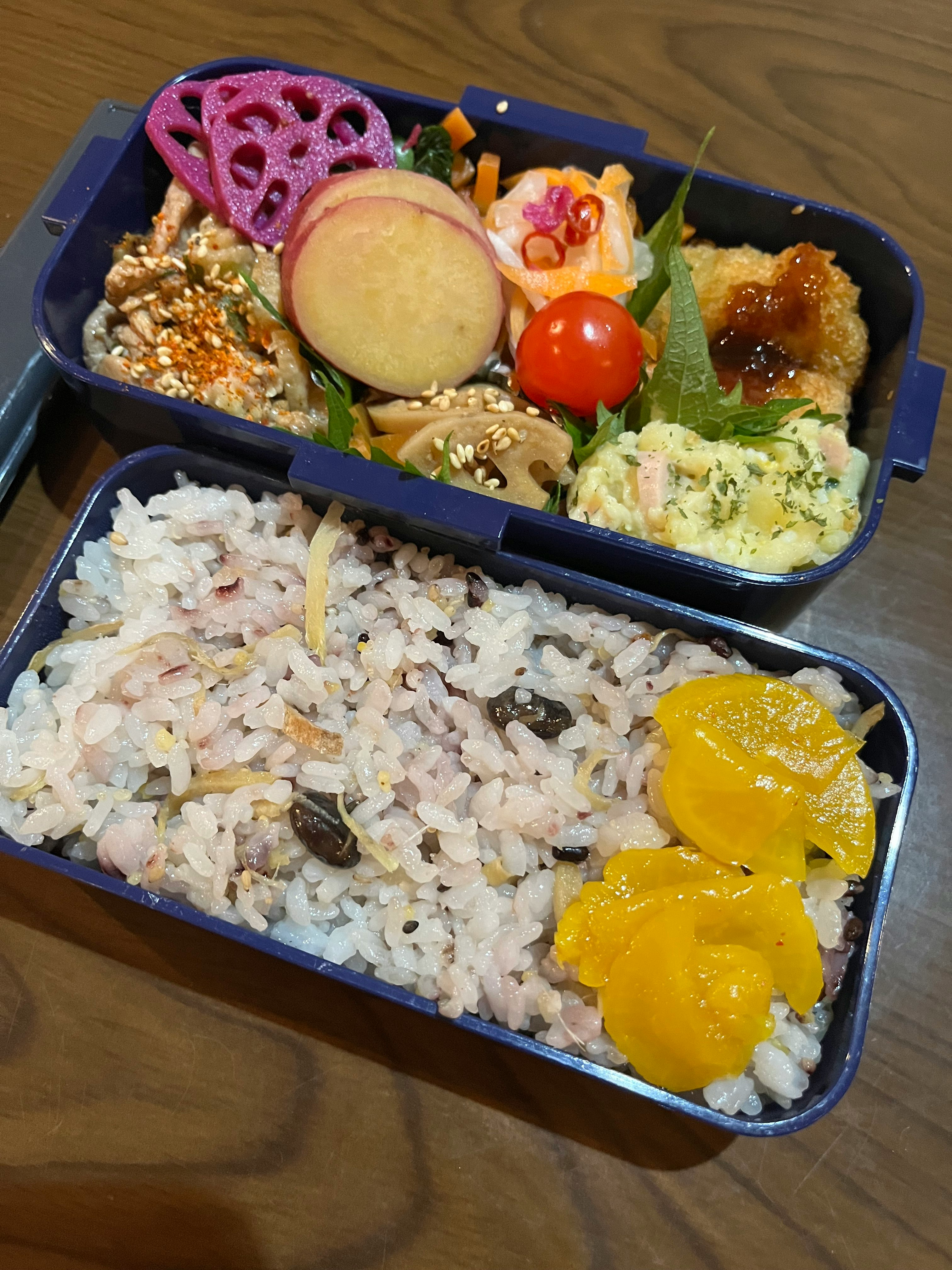 Colorful bento box filled with various dishes and rice