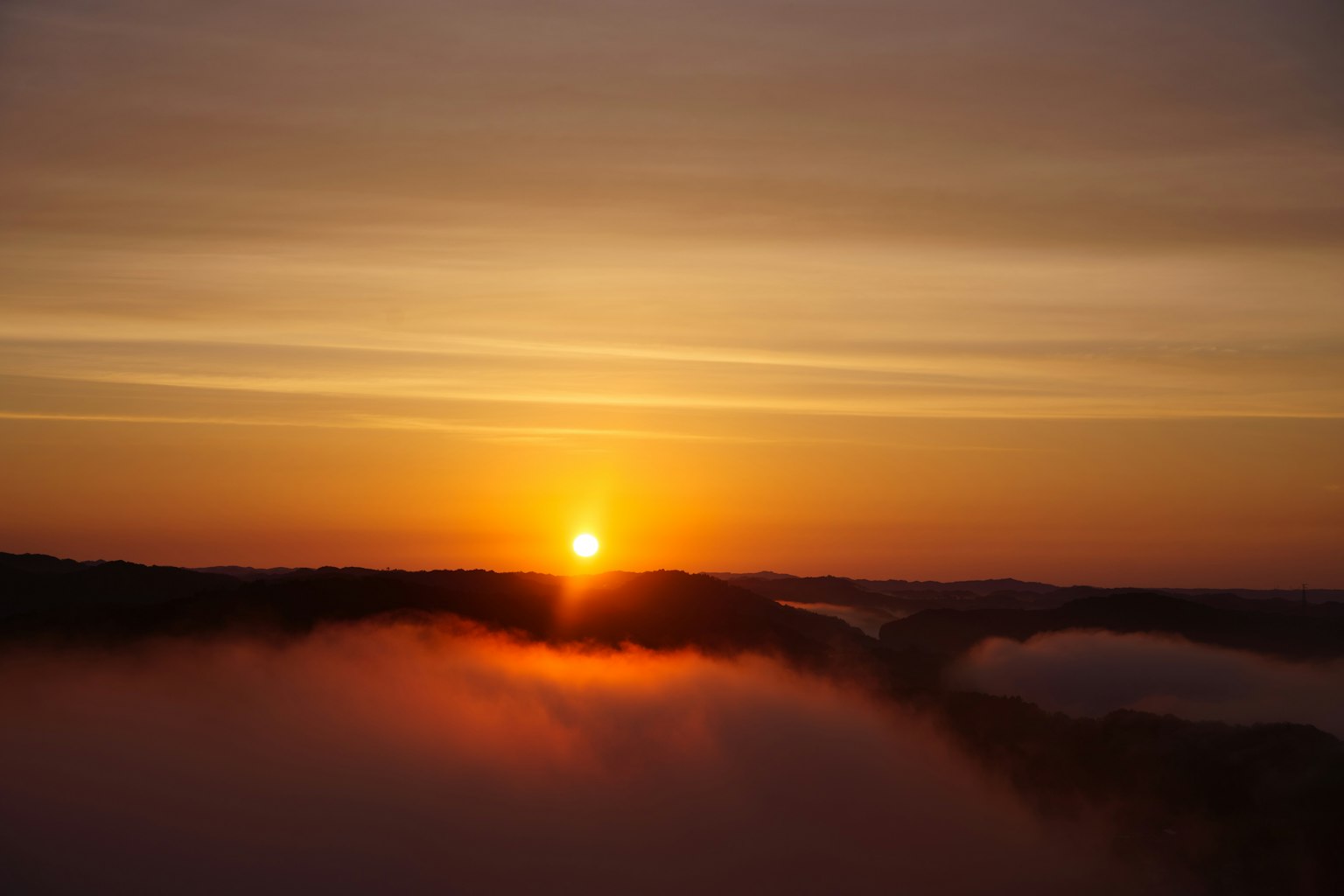 Hermoso amanecer sobre montañas cubiertas de niebla