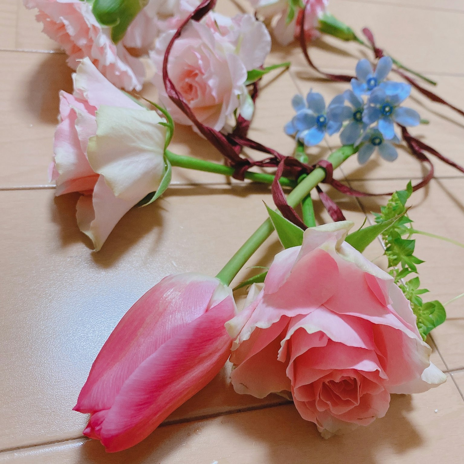 Arrangement of pink roses and tulips with blue flowers