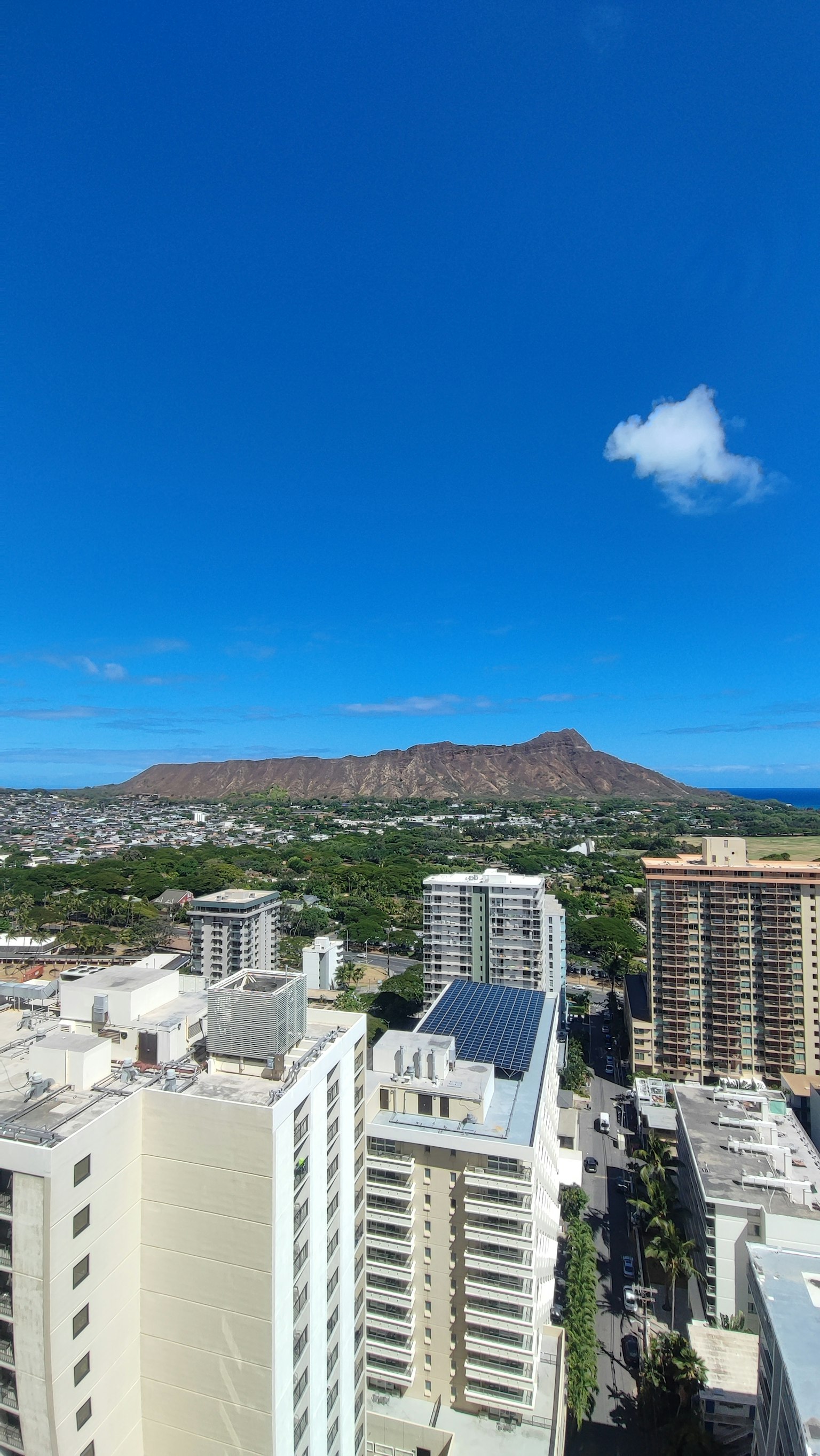 Gedung tinggi yang menghadap Diamond Head dan langit biru cerah