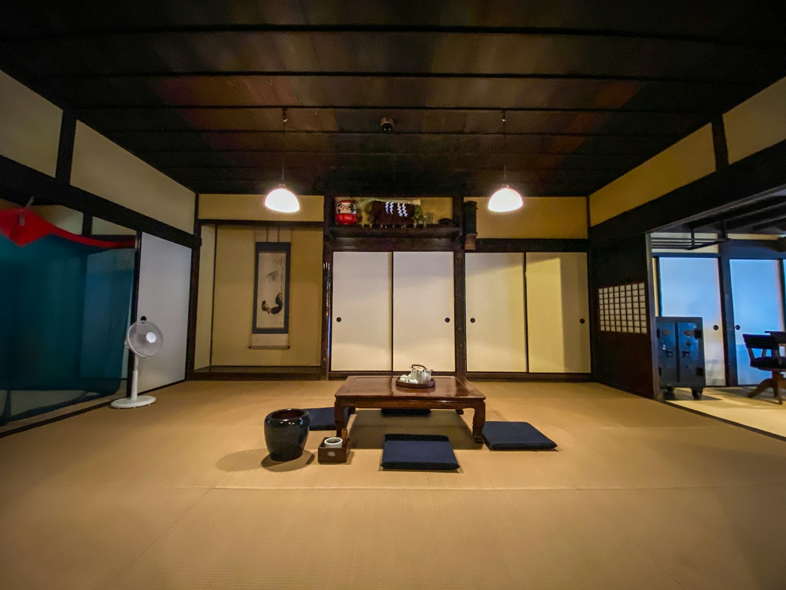 Traditionelles japanisches Innendesign mit Tatamiboden, Holzboden, niedrigen Tisch mit Kissen, einfacher Beleuchtung und japanischer Dekoration