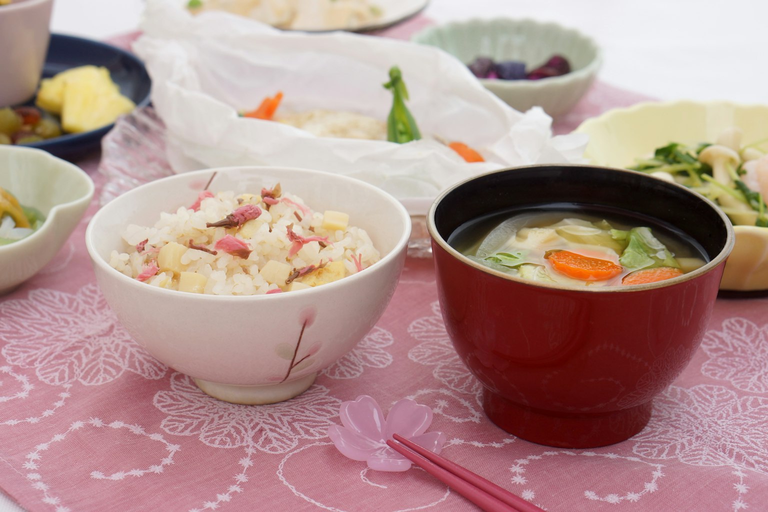 Ein Tisch mit bunten Gerichten mit einer Schüssel weißen Reis und einer roten Misosuppe