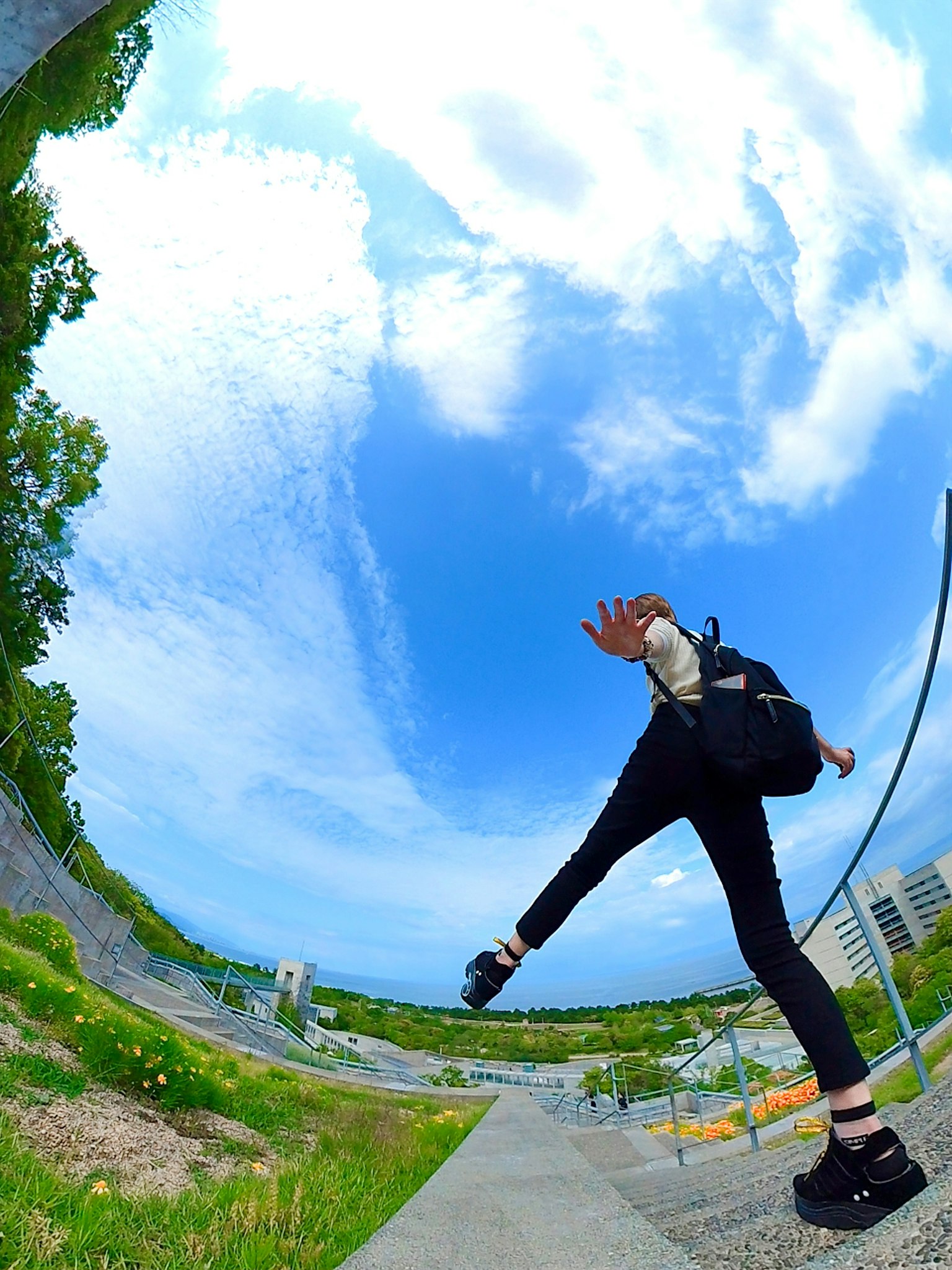 Ảnh fisheye của một người đang nâng một chân dưới bầu trời xanh