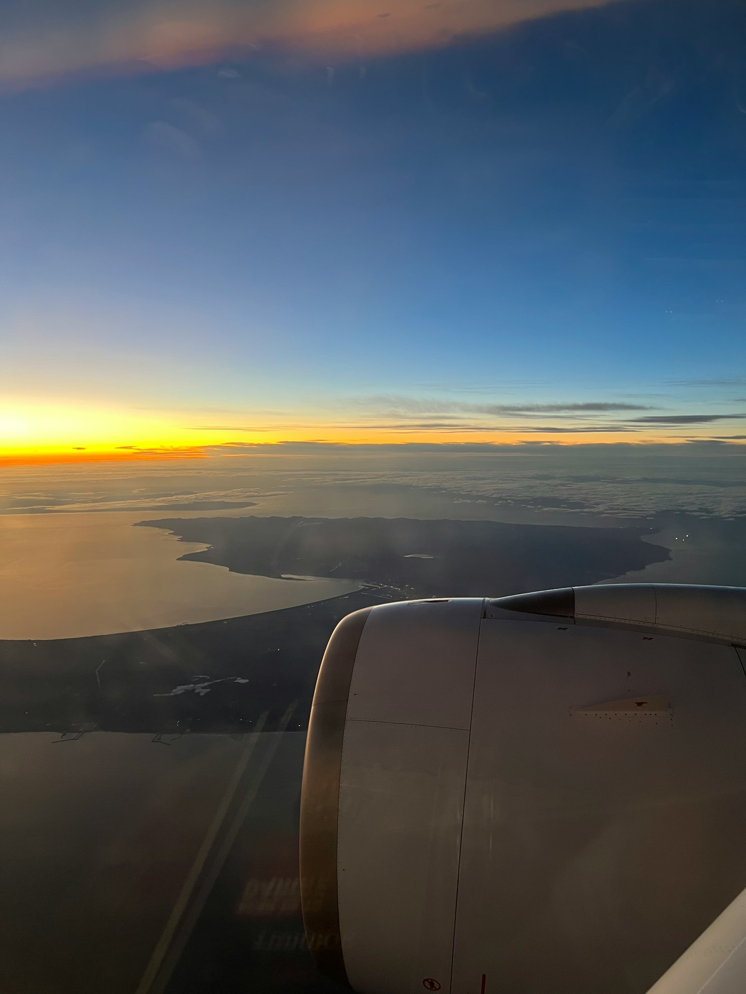 Vista del atardecer y el mar desde la ventana del avión