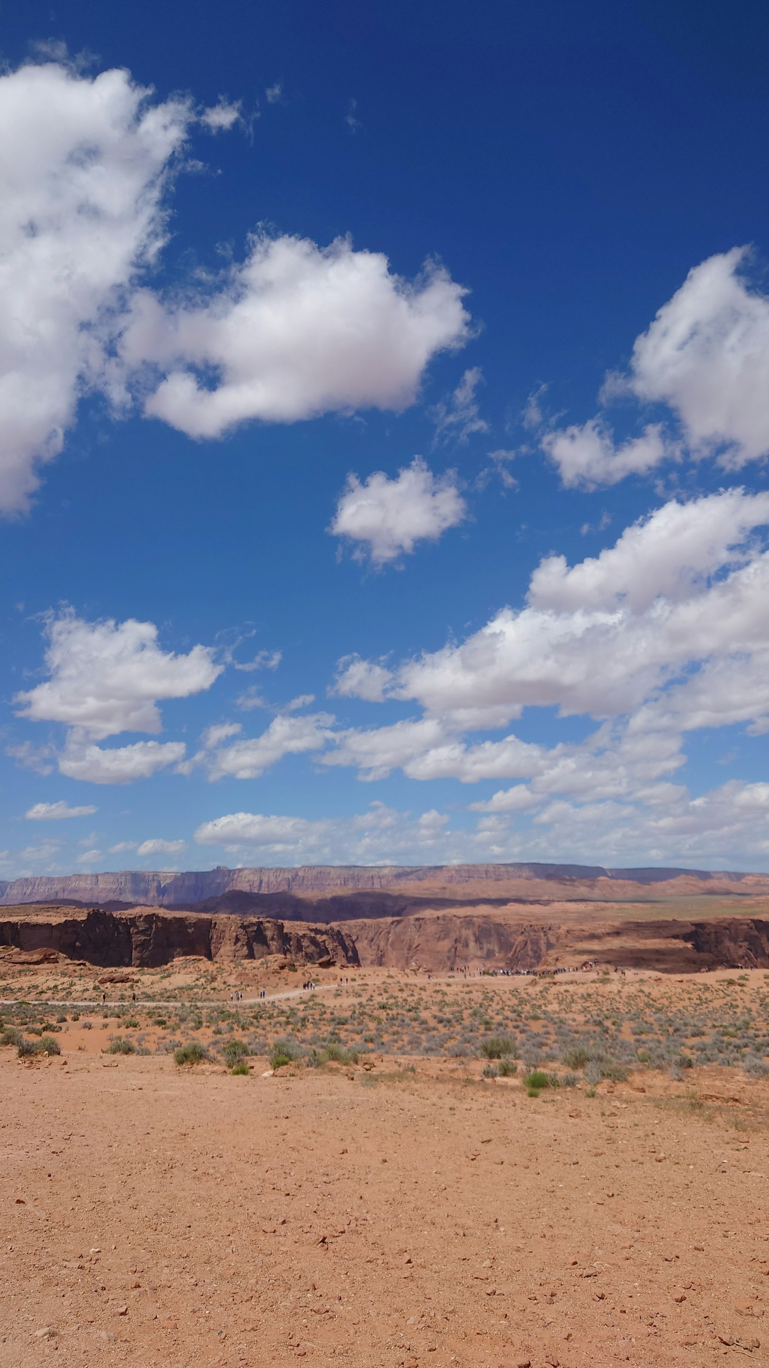 Paysage désertique sous un ciel bleu avec des nuages blancs