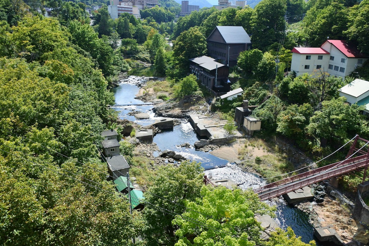 Eine malerische Ansicht von alten Gebäuden, umgeben von einem Fluss und üppigem Grün