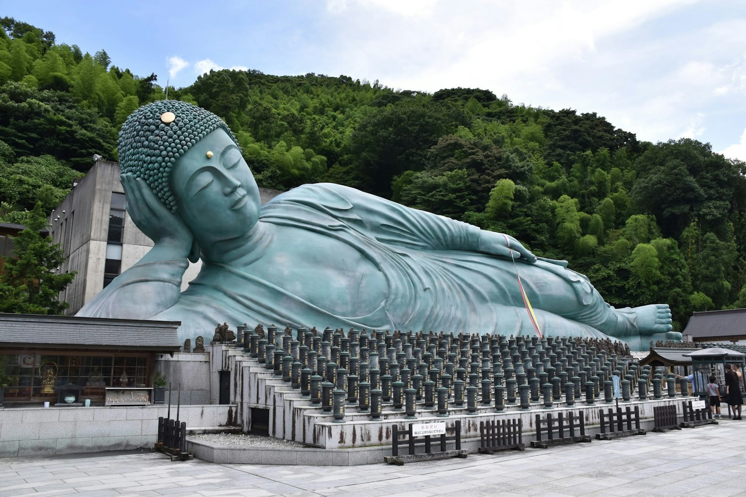 Estatua grande de Buda reclinado con colinas verdes al fondo