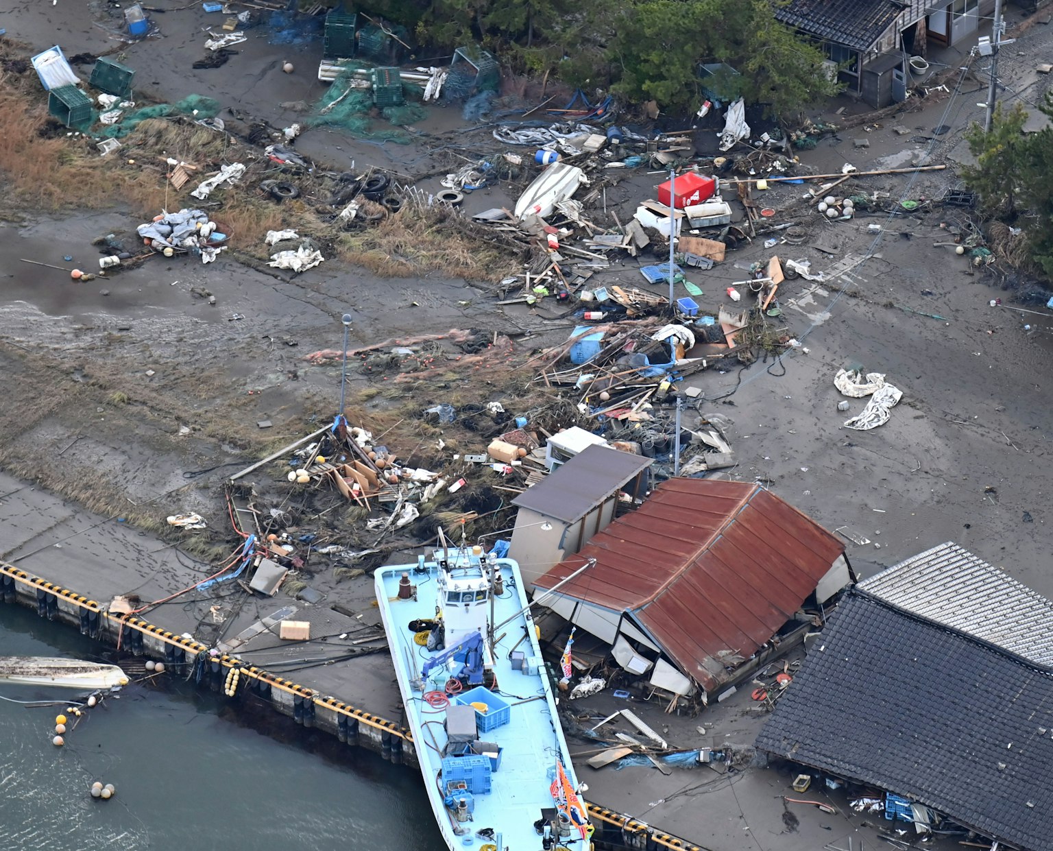Beschädigte Hafenansicht mit einem zerbrochenen Boot und verstreutem Schutt