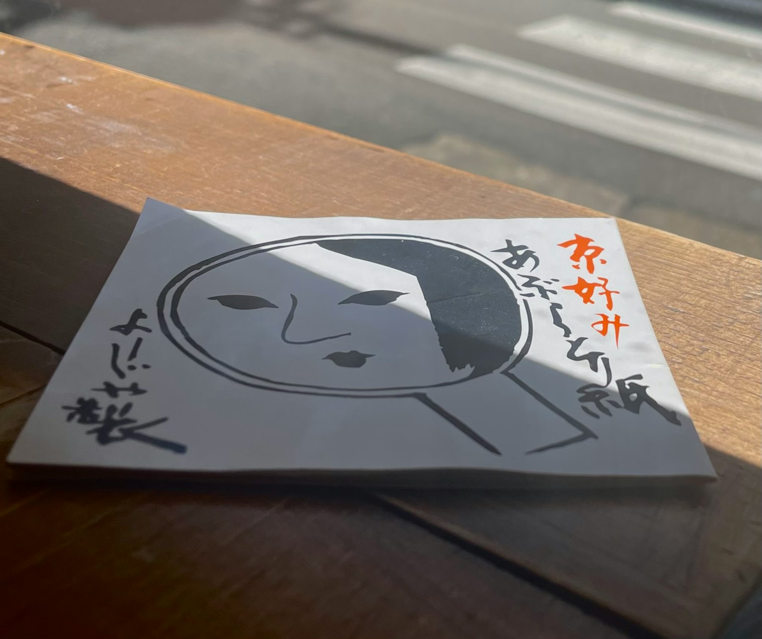 一张白色卡片，上面有简单的面部插图，放在木桌上