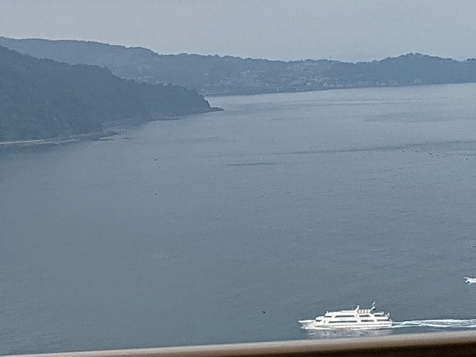 Vue pittoresque de montagnes et de mer calme avec un yacht blanc