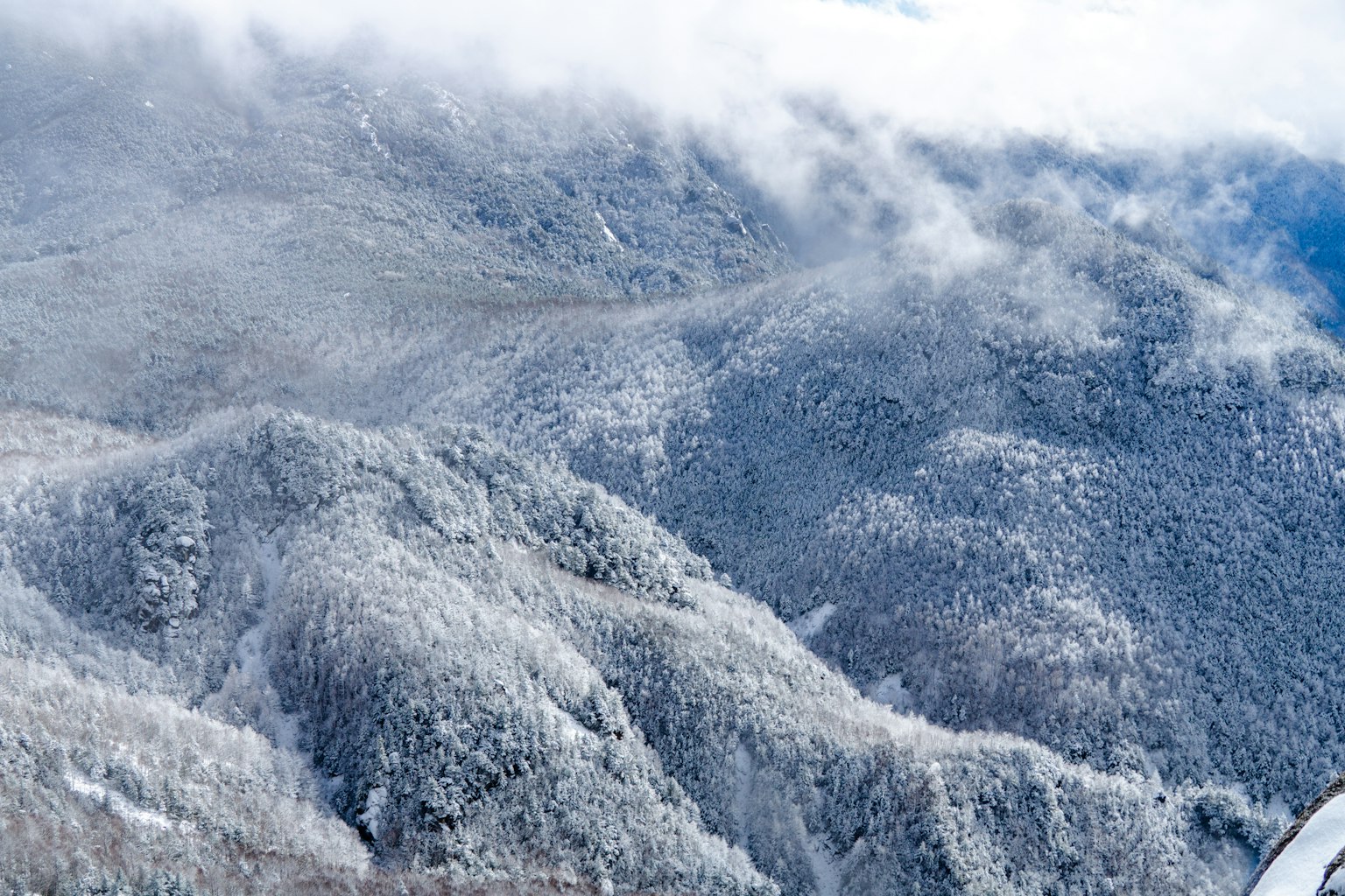 Schneebedeckte Berge mit bewölktem Himmel