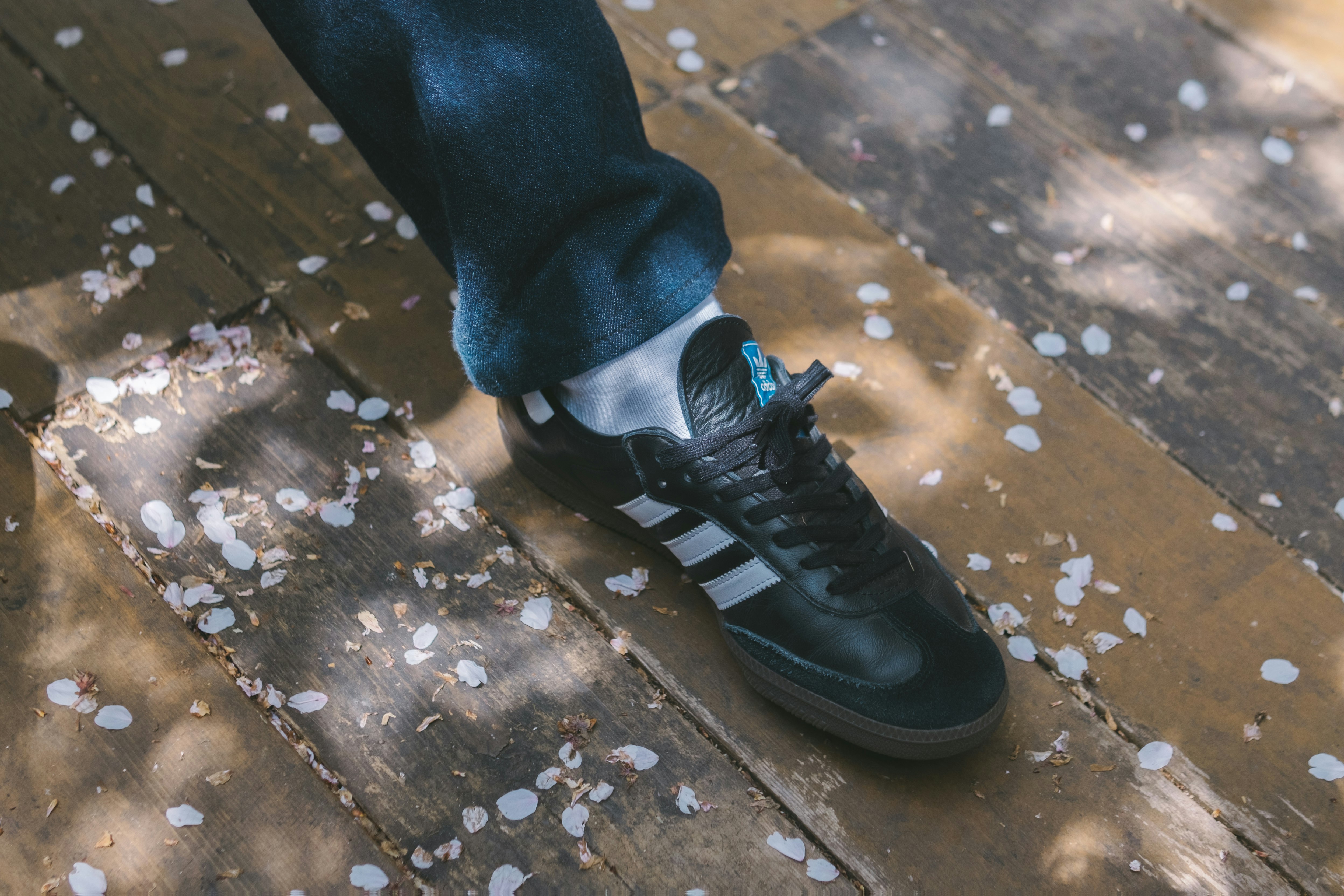 Hände beim Anziehen von Sneakers auf einem Betonweg